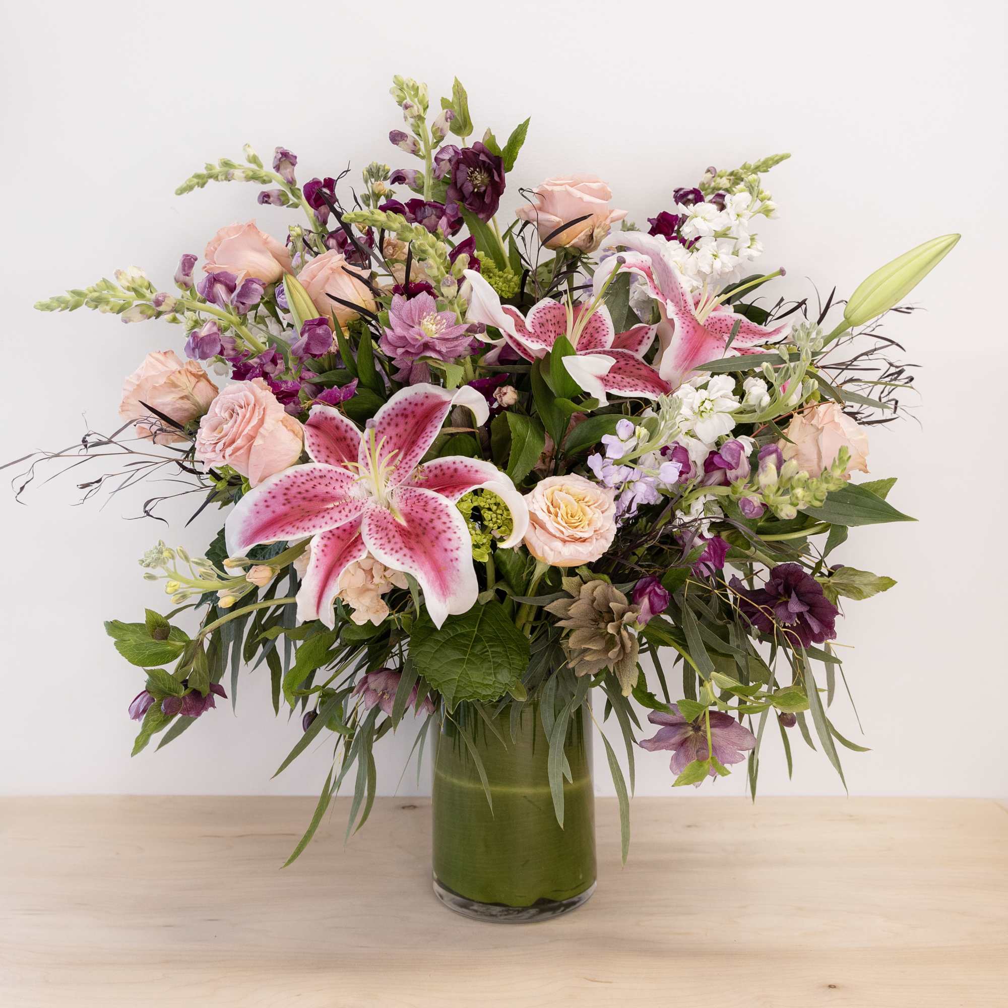 Pink lilies and roses arranged in a glass vase