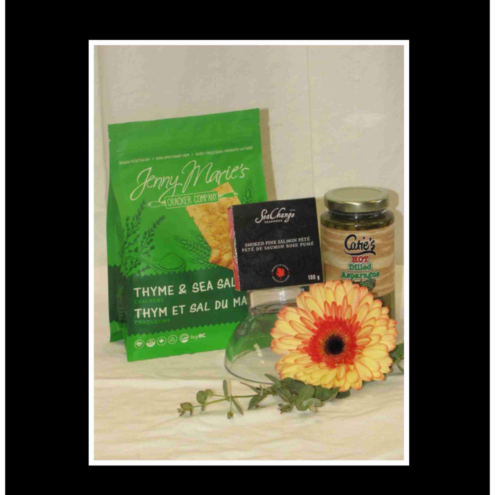 Gift basket with crackers, salmon pâté, asparagus dip, and a gerbera daisy