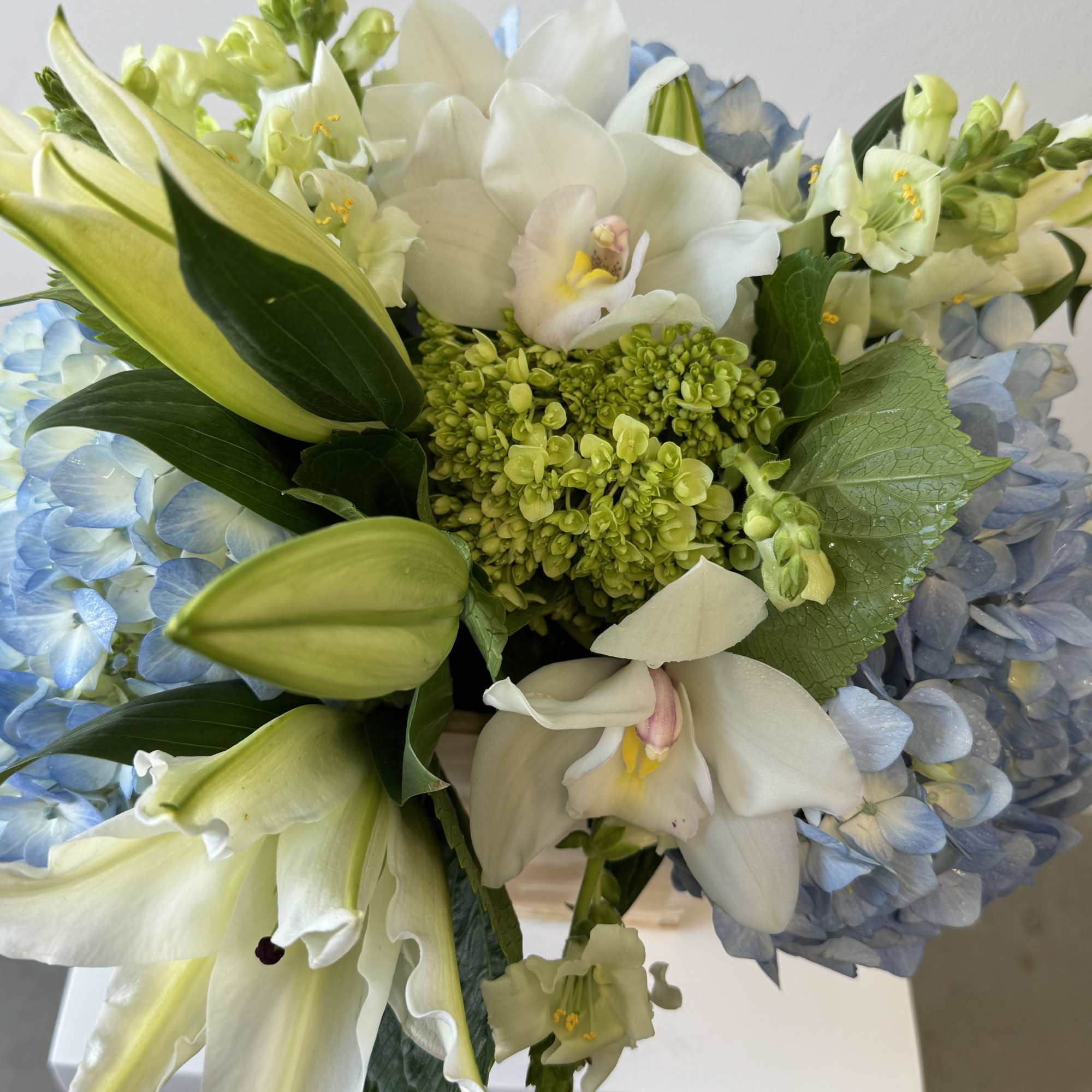 White lilies and blue hydrangeas in a bouquet