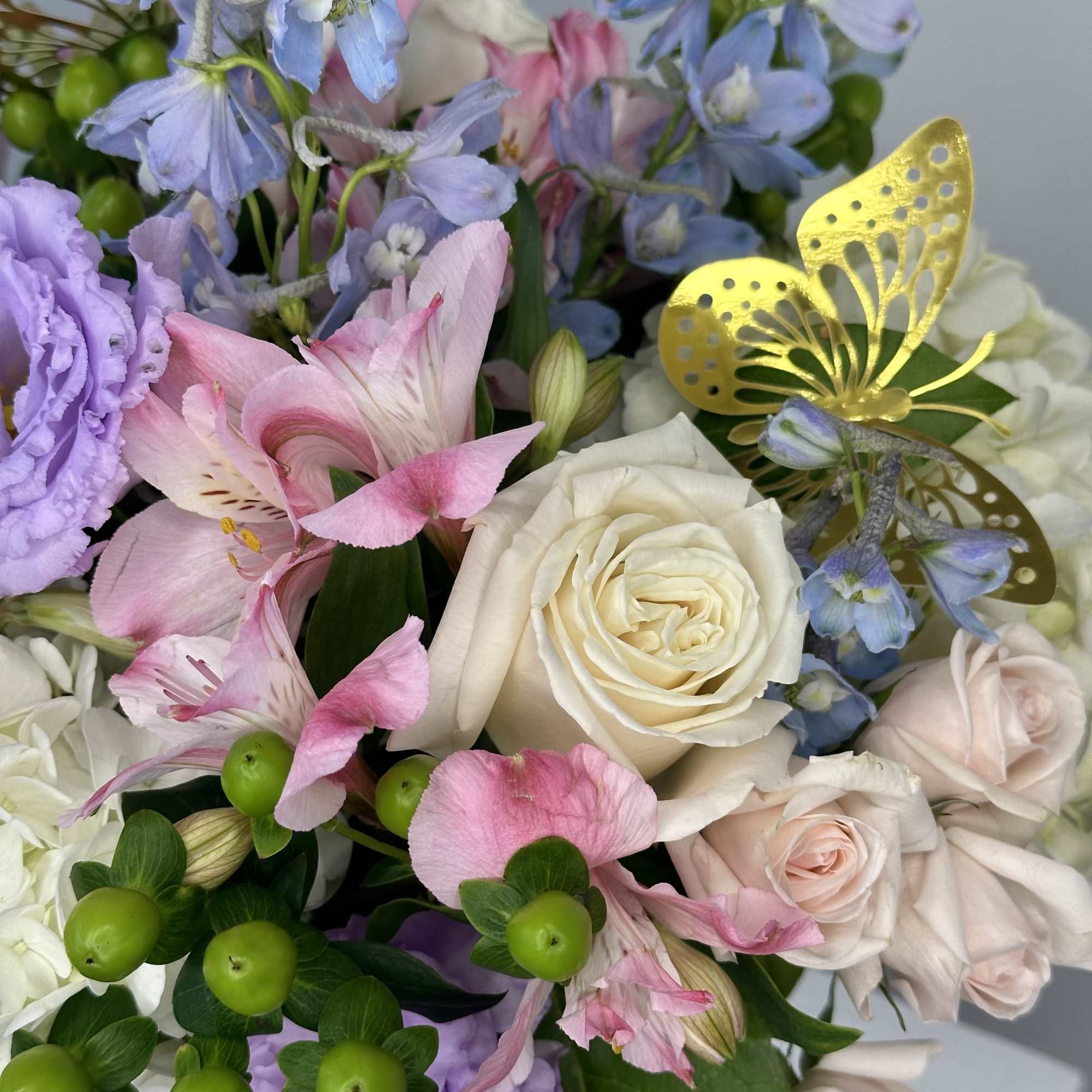 Pastel bouquet with roses, lilies, and blue flowers
