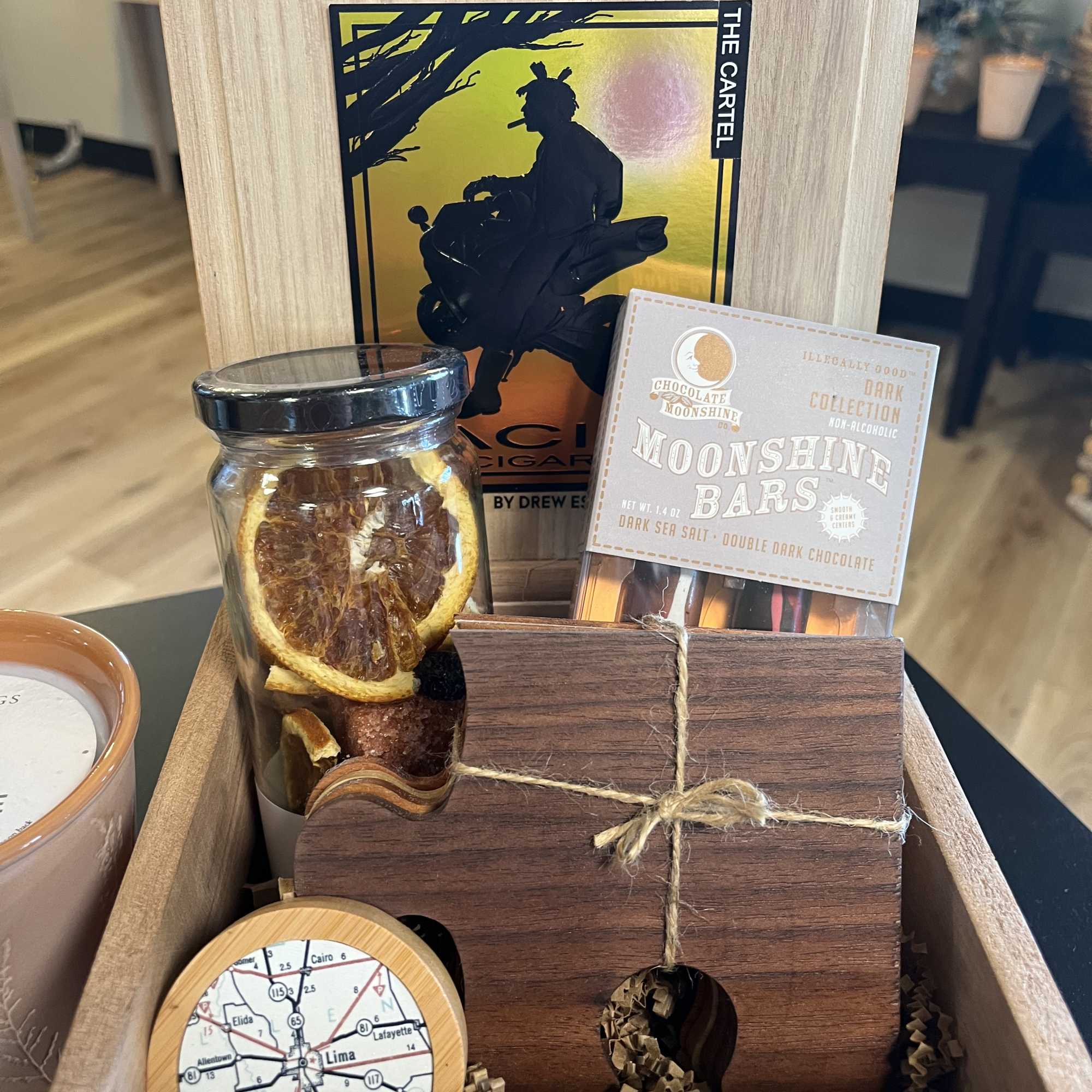 Gift basket with candles, chocolate bars, and a jar of dried citrus slices