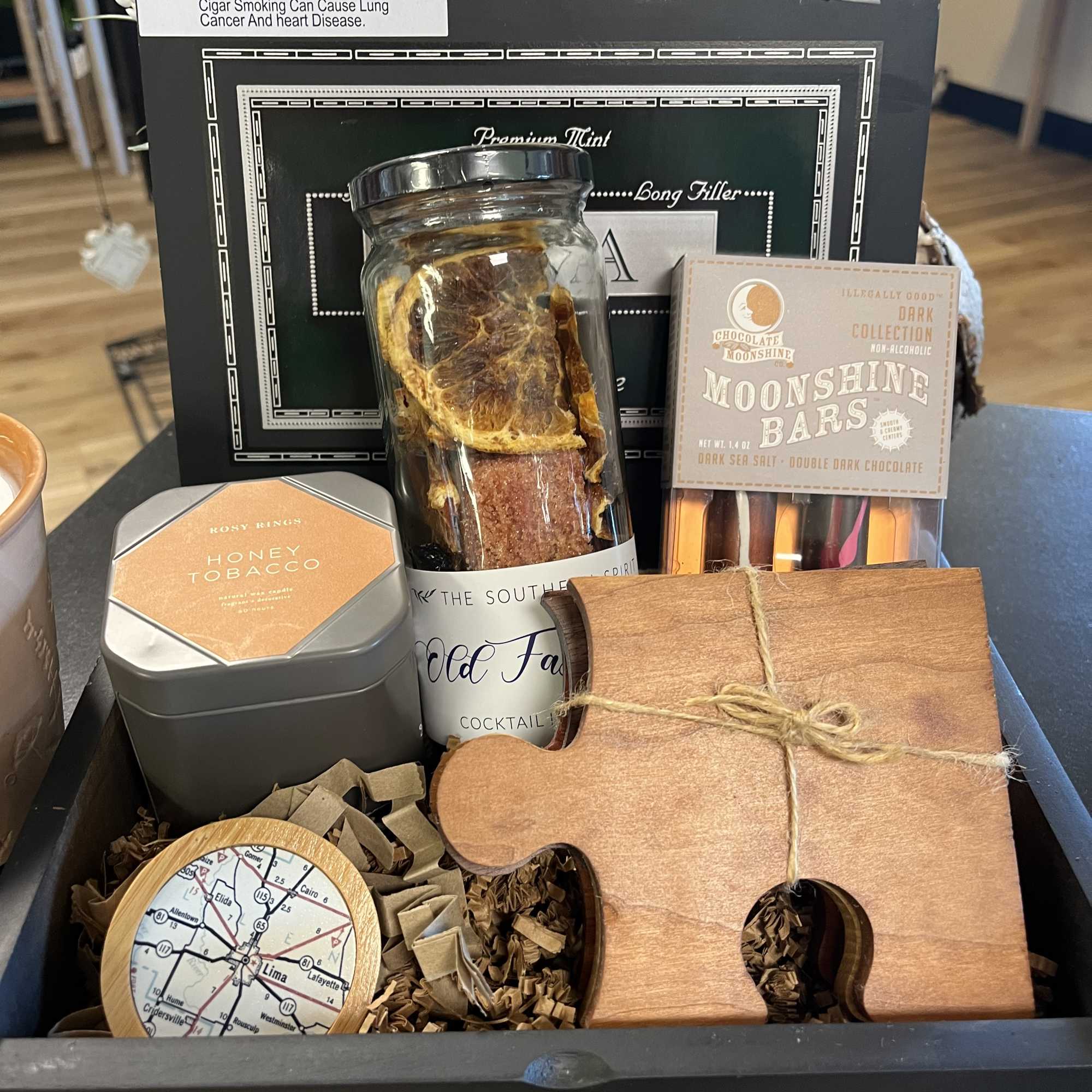 Gift basket with cigars, chocolates, and a wooden puzzle piece