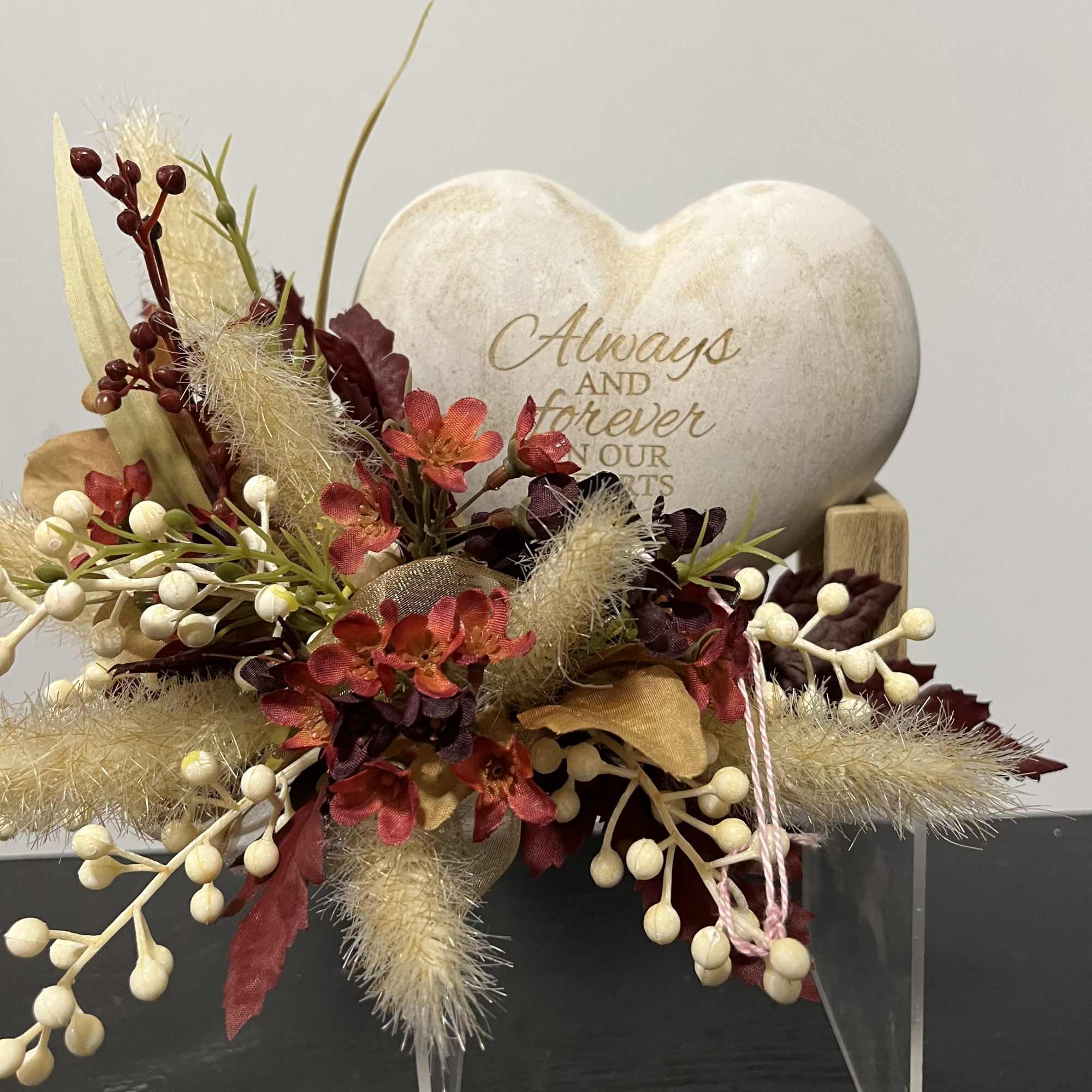Heart-shaped memorial plaque with a faux floral arrangement in red, cream, and gold