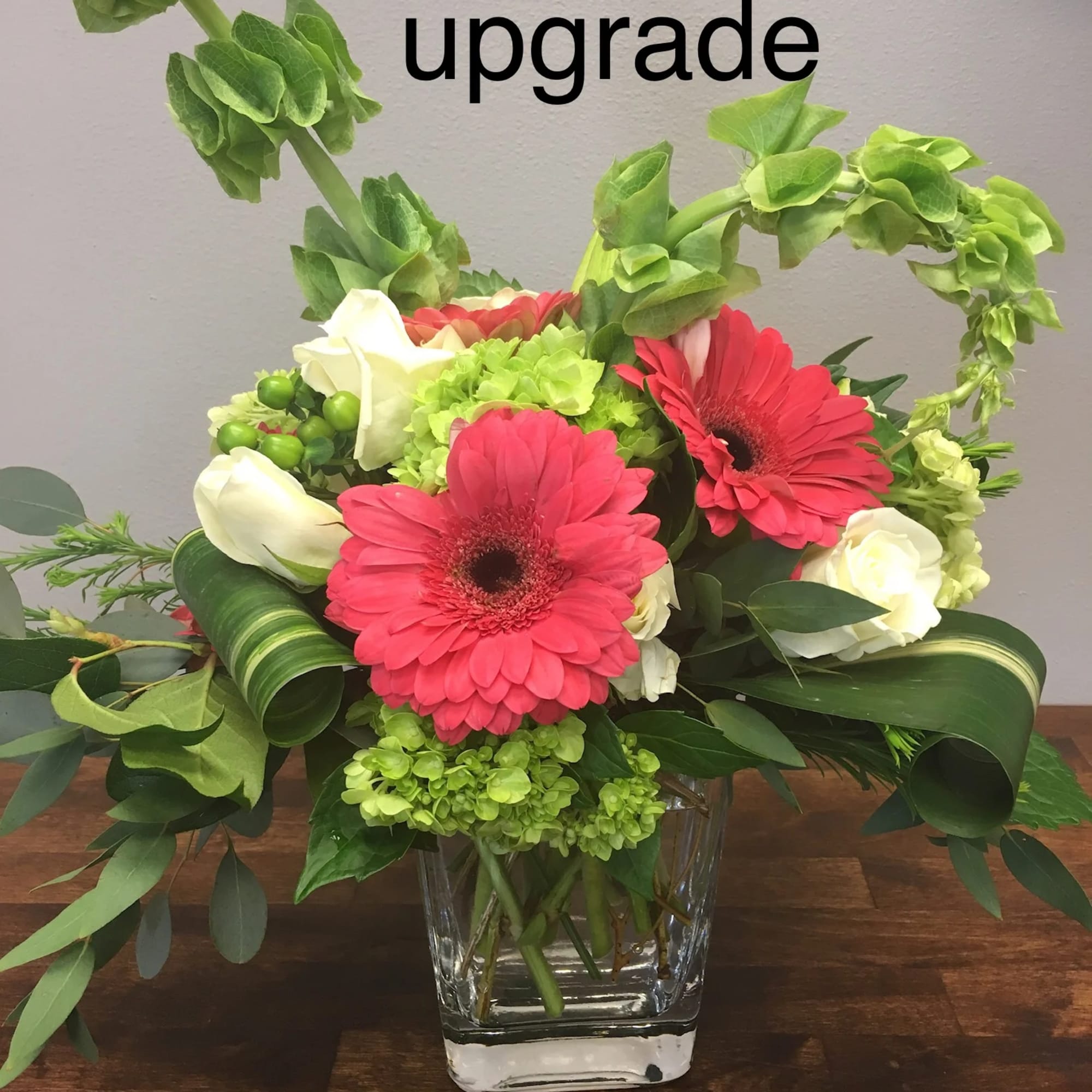 Pink gerbera daisies and white roses in a clear glass vase