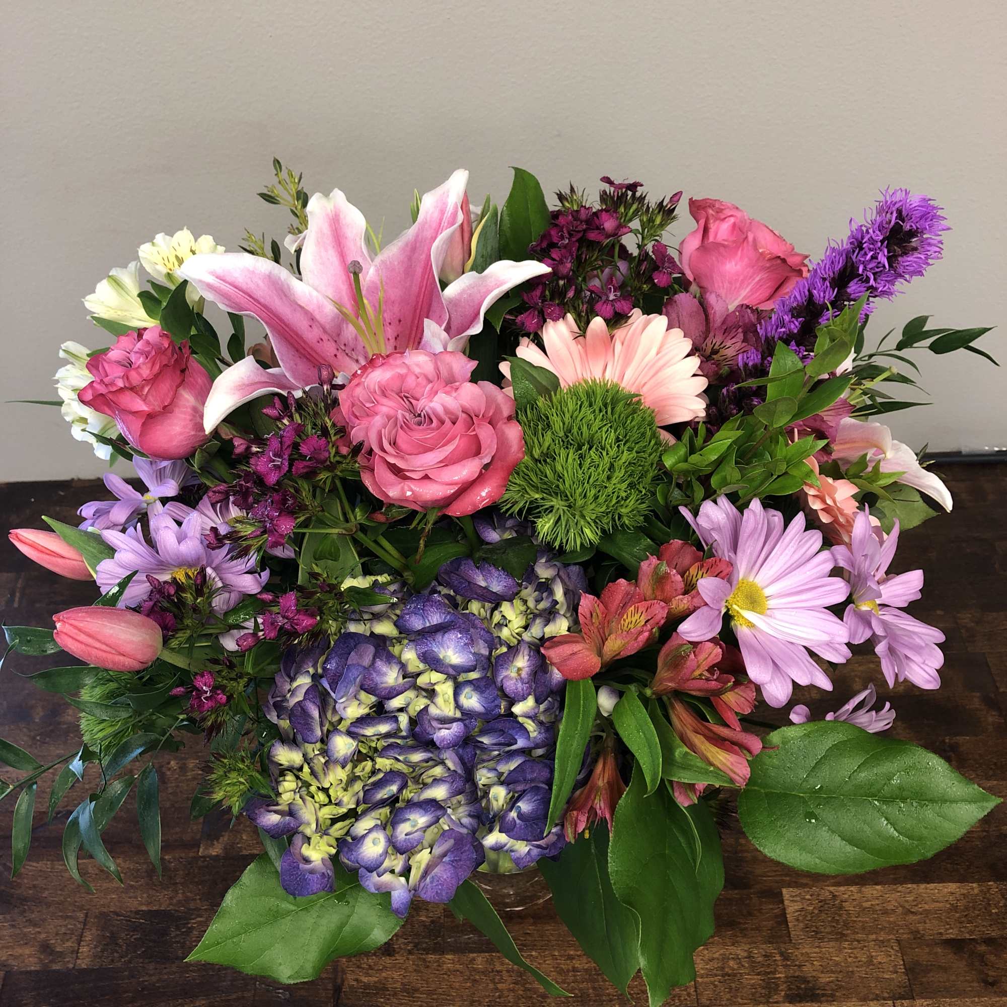Mixed bouquet with pink lilies, roses, daisies, and purple hydrangea
