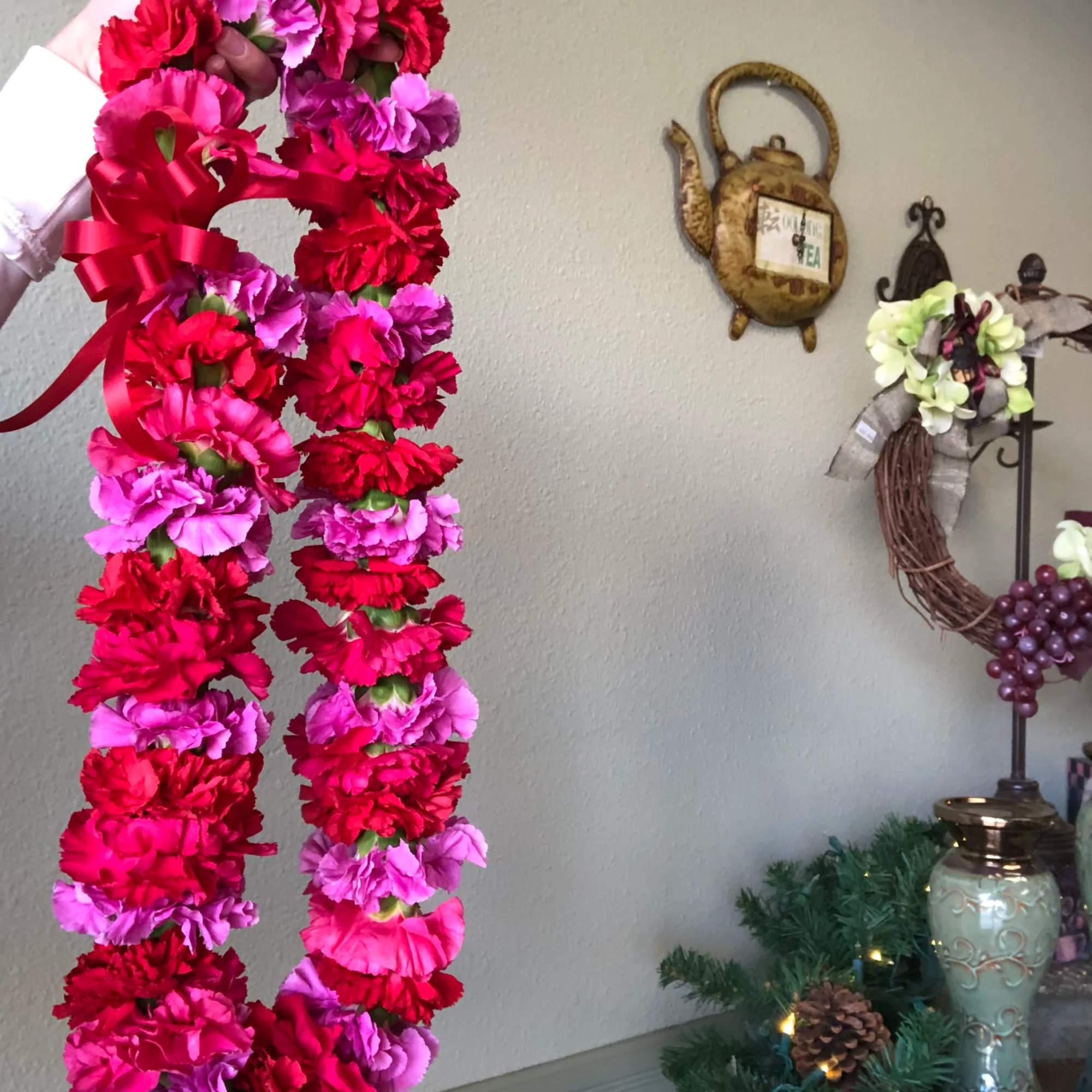 Pink and red carnation lei with a satin ribbon