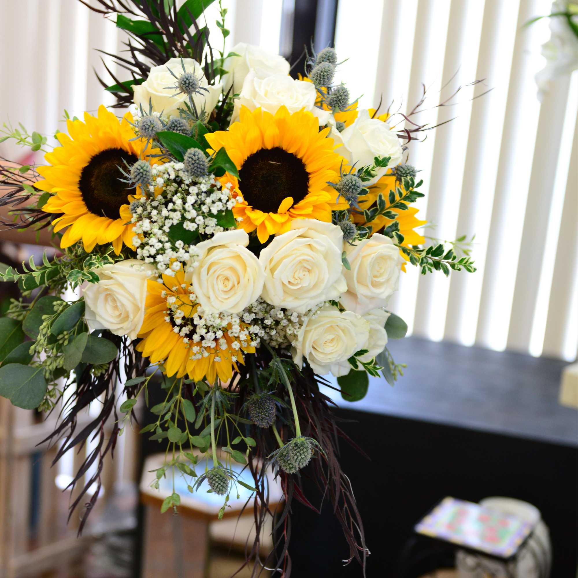 Bouquet of sunflowers and white roses with greenery
