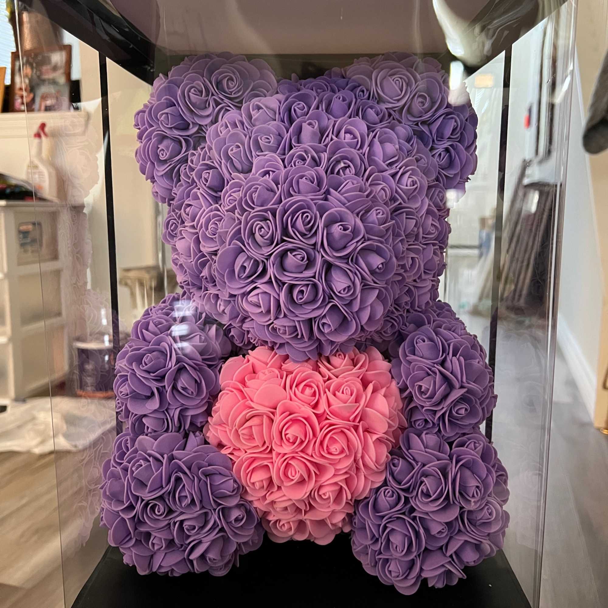 Purple and pink teddy bear made of roses inside a clear display box
