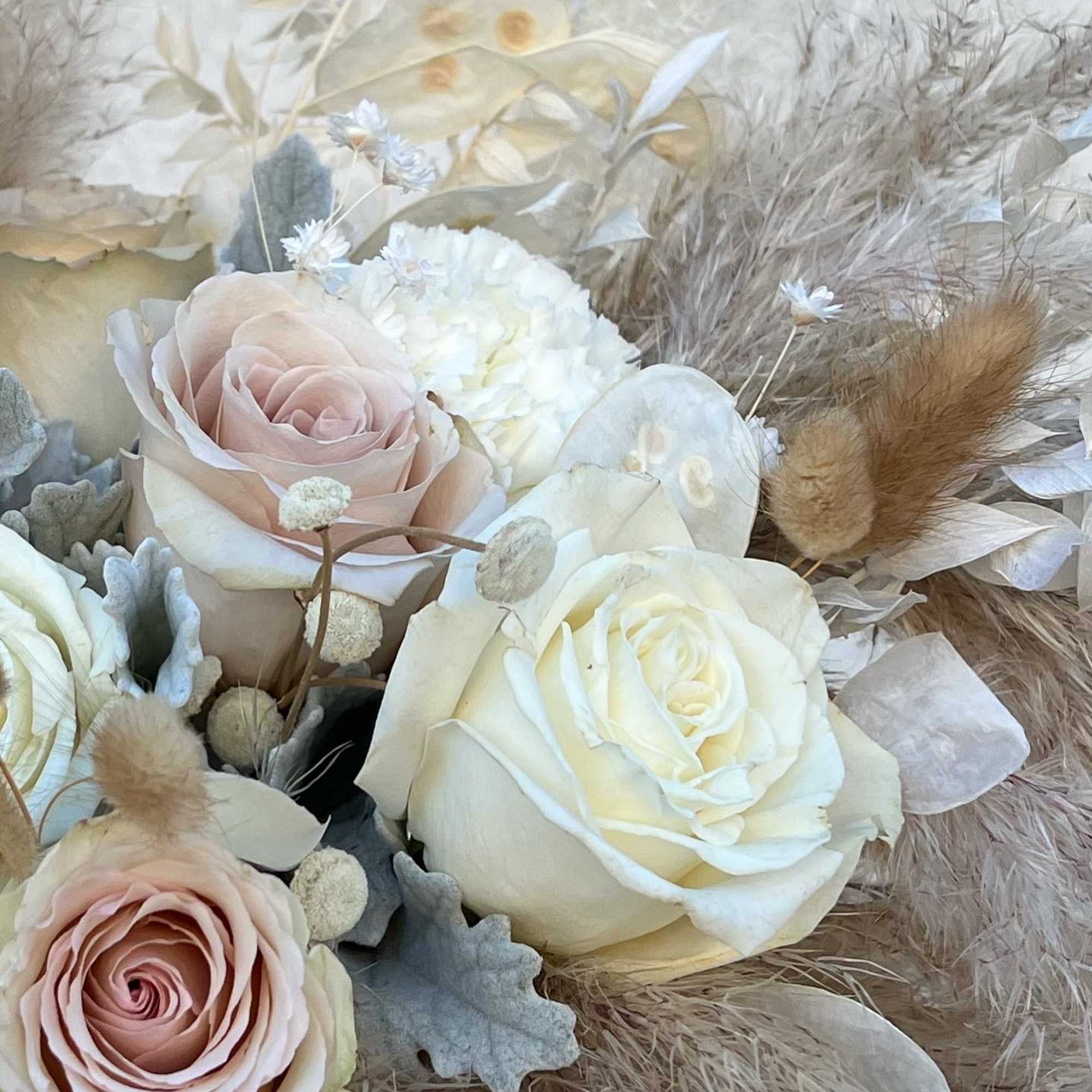 Bouquet of pale roses and white blooms with dried grasses
