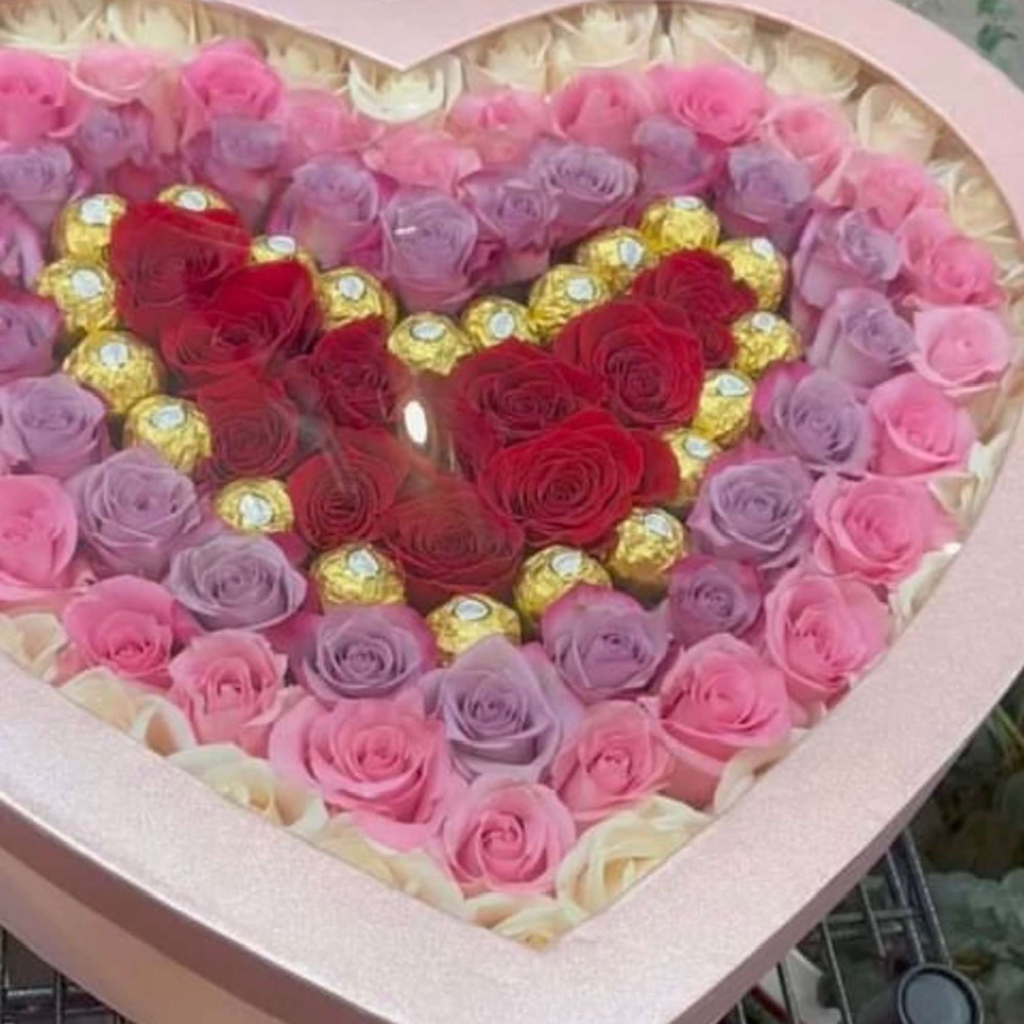 Heart-shaped box of pink, lavender, and red roses with gold chocolates