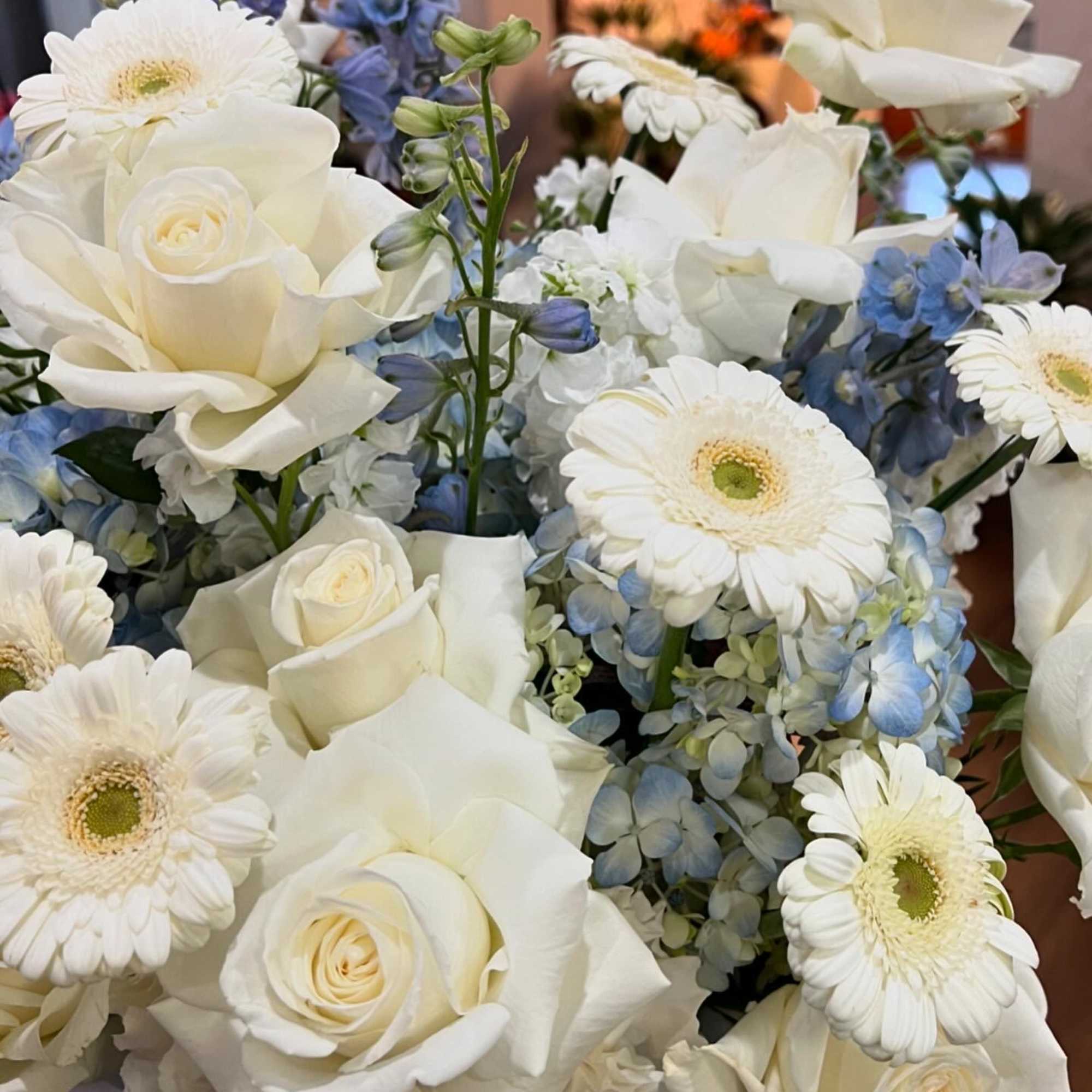 A mixed of Hydrangea, gerbera, roses, carnation, stock, and delphinium in blue