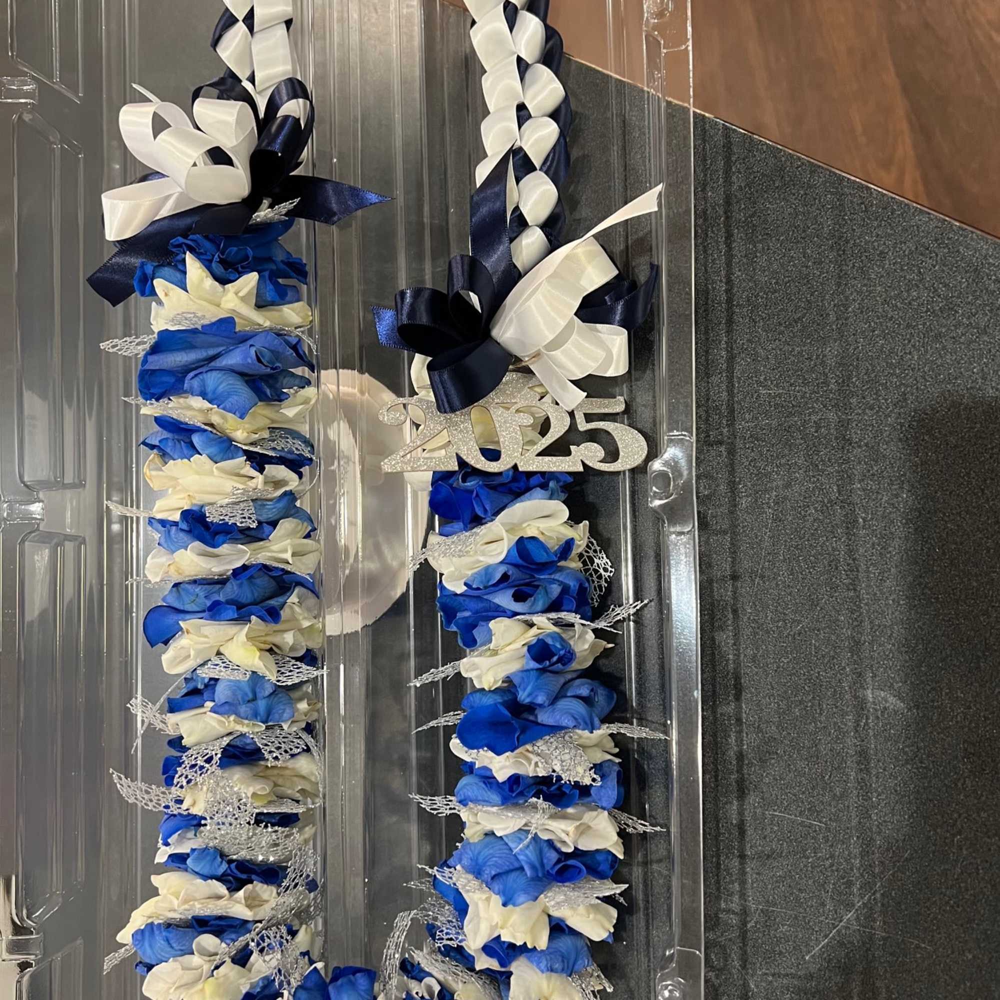Blue and white floral lei with a 2025 charm and ribbon bow