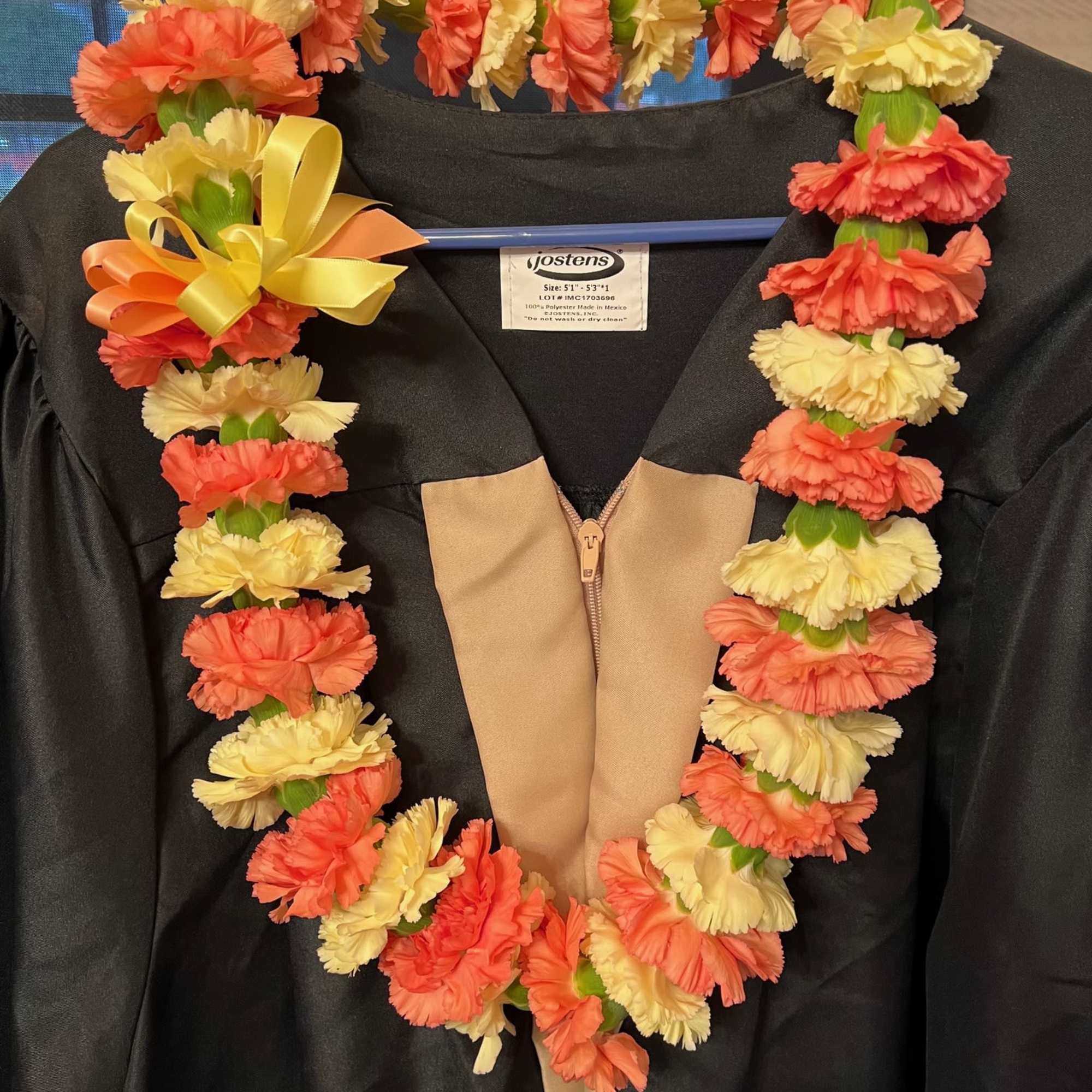 Flower lei draped over a black graduation gown