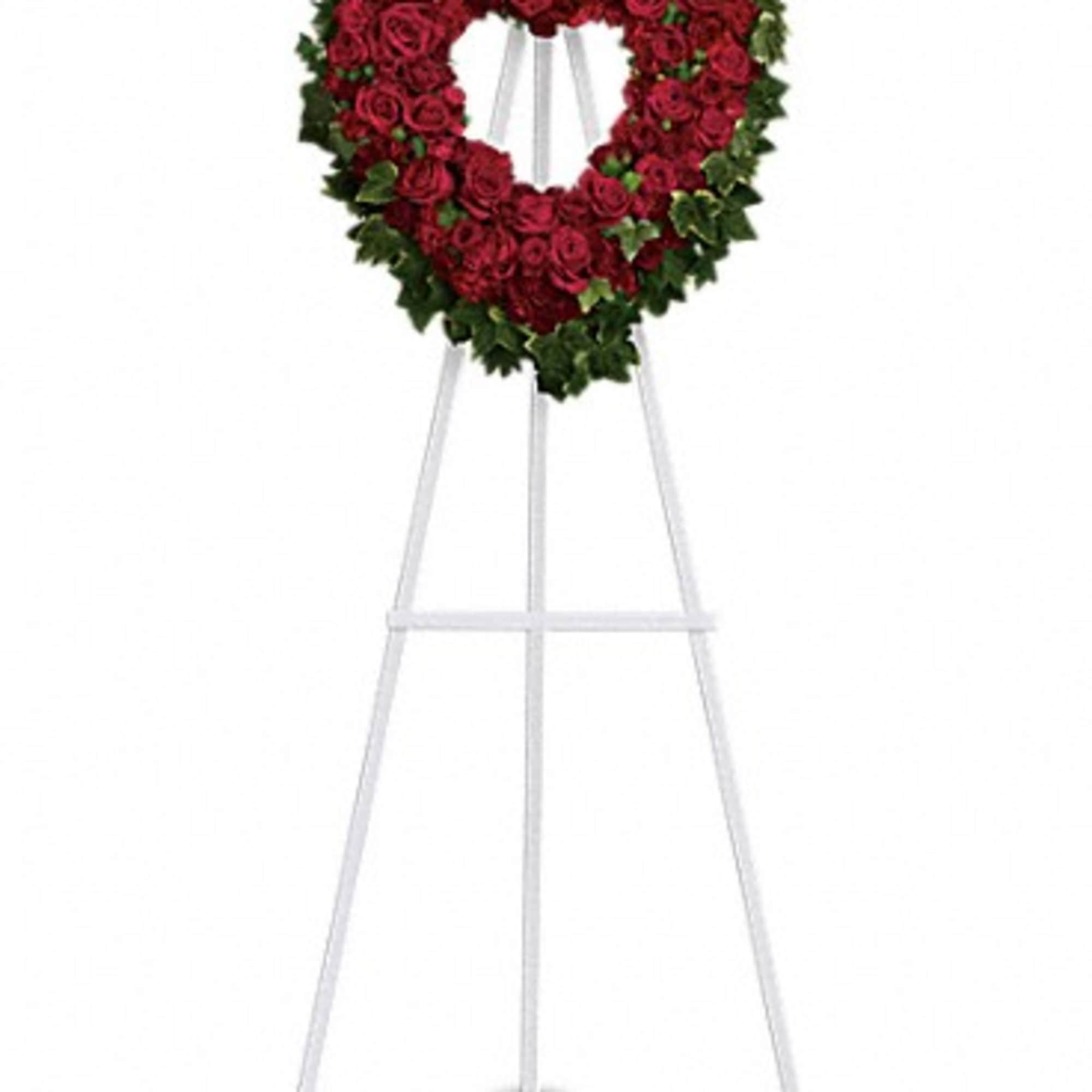 Heart-shaped standing wreath of red roses on a white easel
