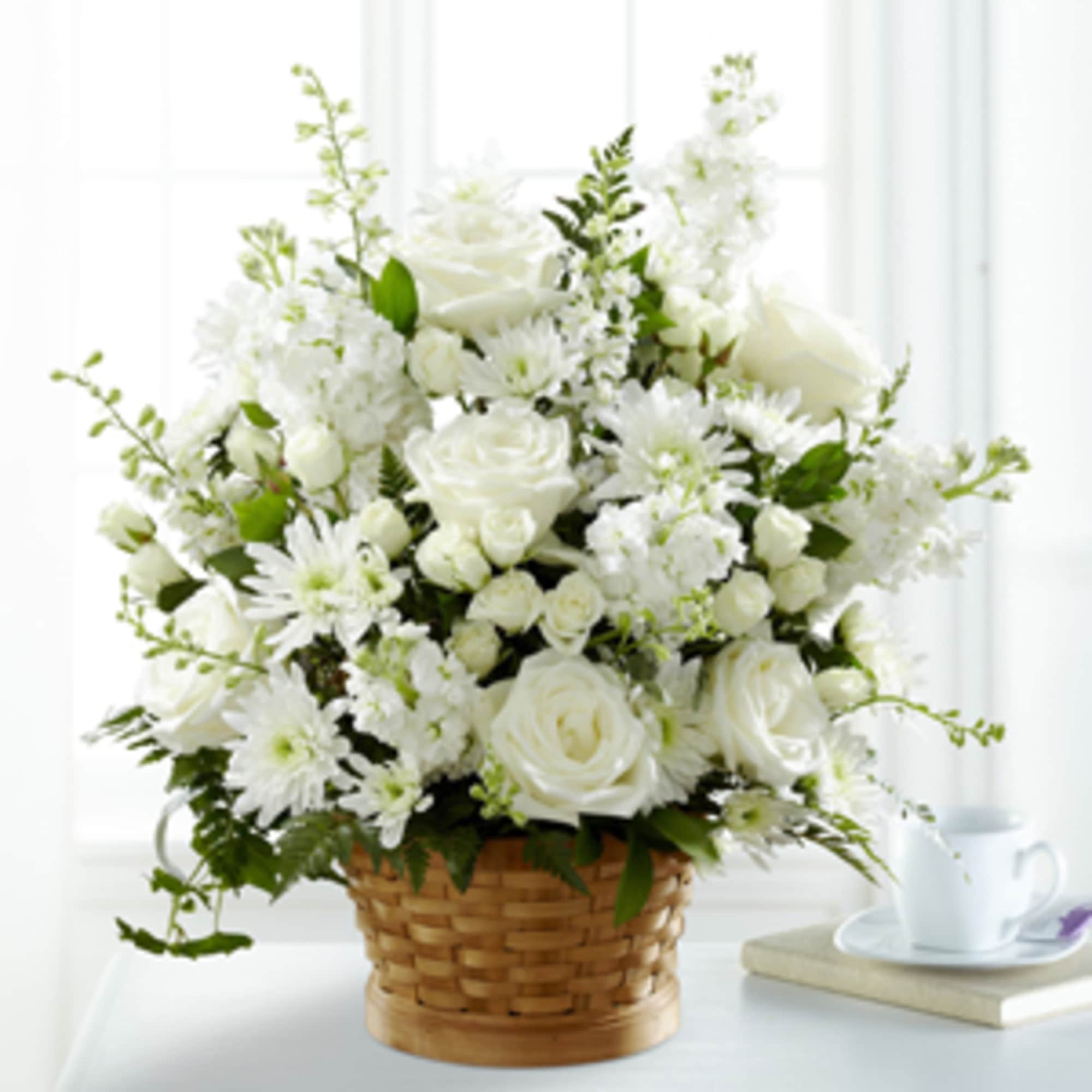 White roses and daisies arranged in a wicker basket