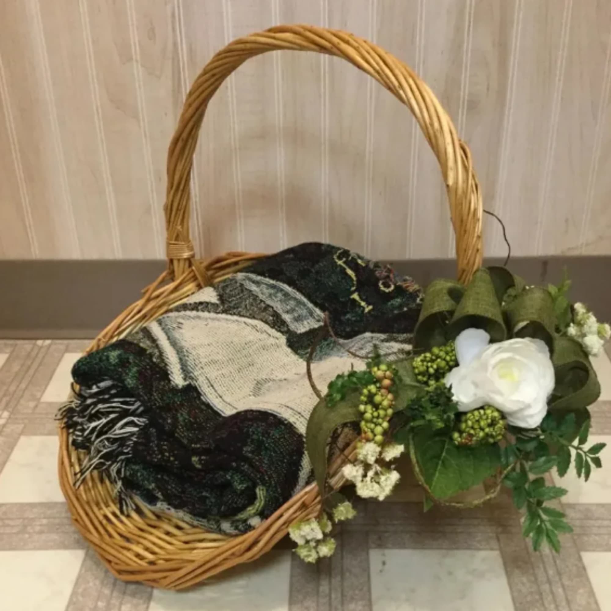 Wicker basket with a folded blanket and white floral accent