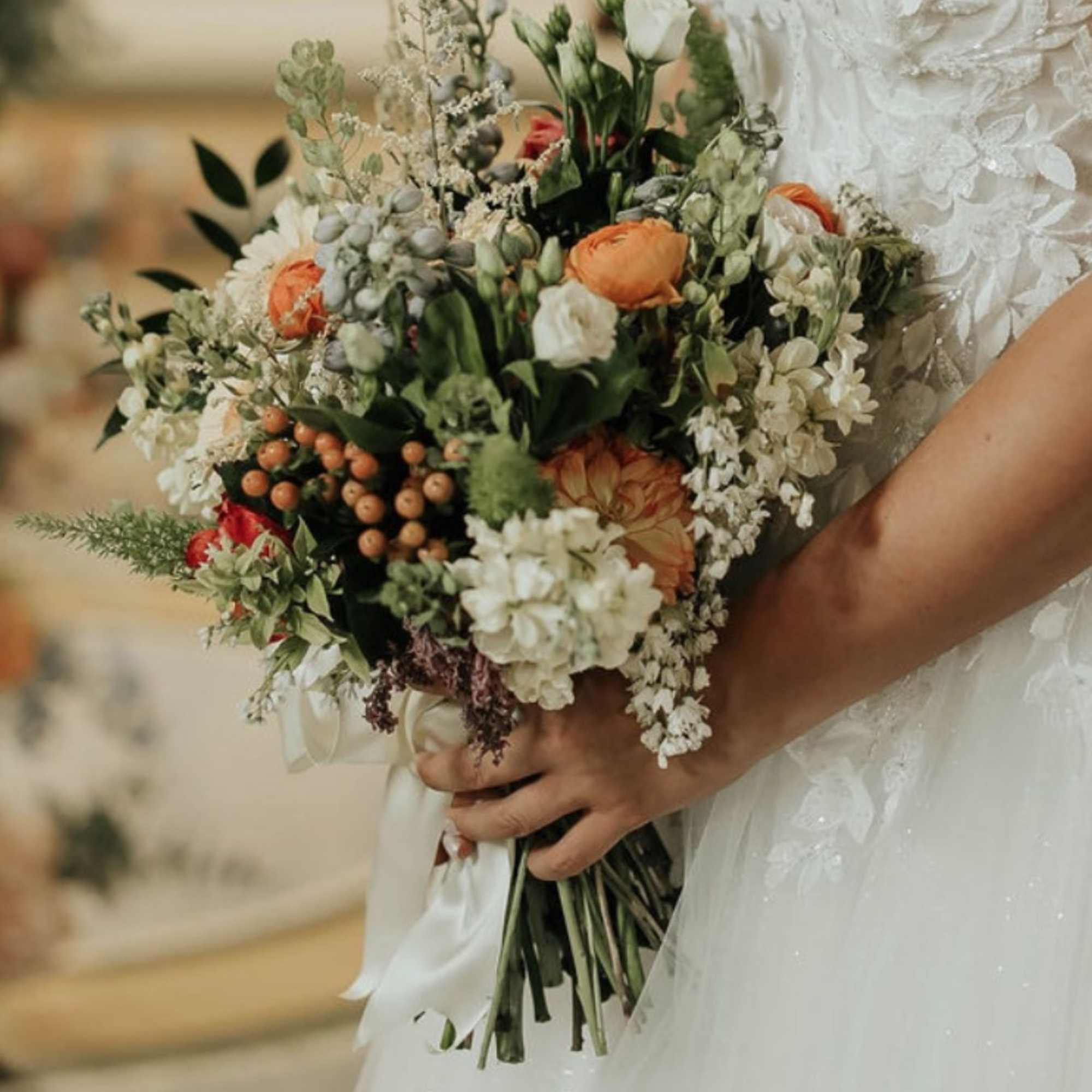 Bridal bouquet of white and peach flowers with greenery