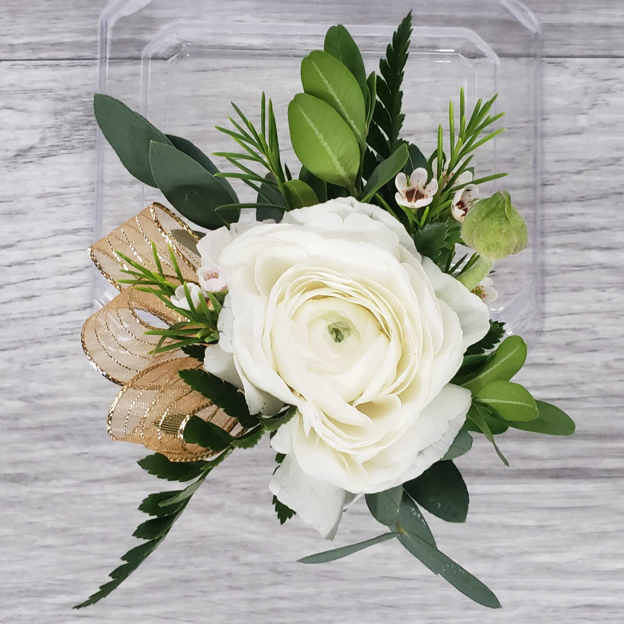 White ranunculus bouquet with greenery and gold ribbon