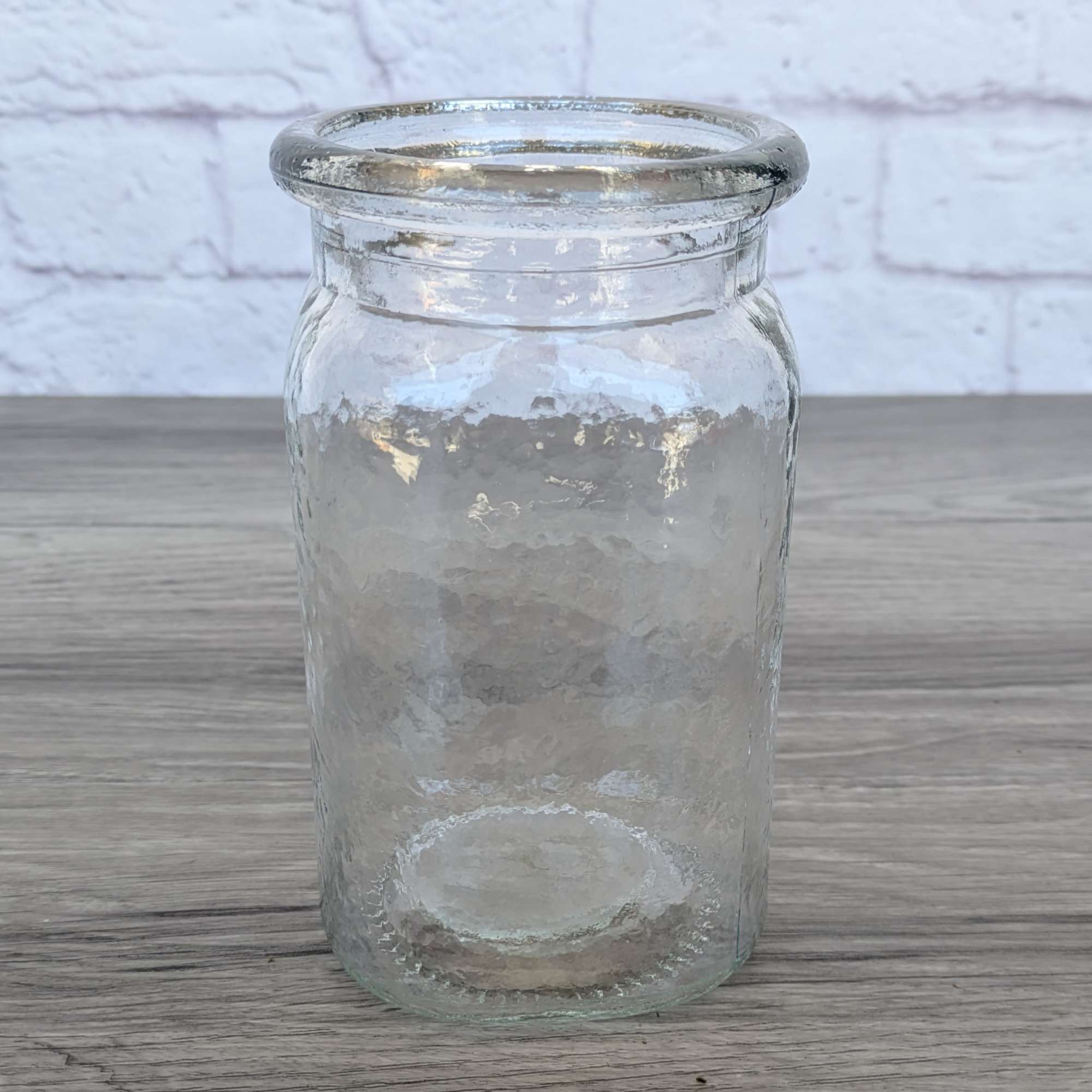 Clear textured glass vase on a wooden surface