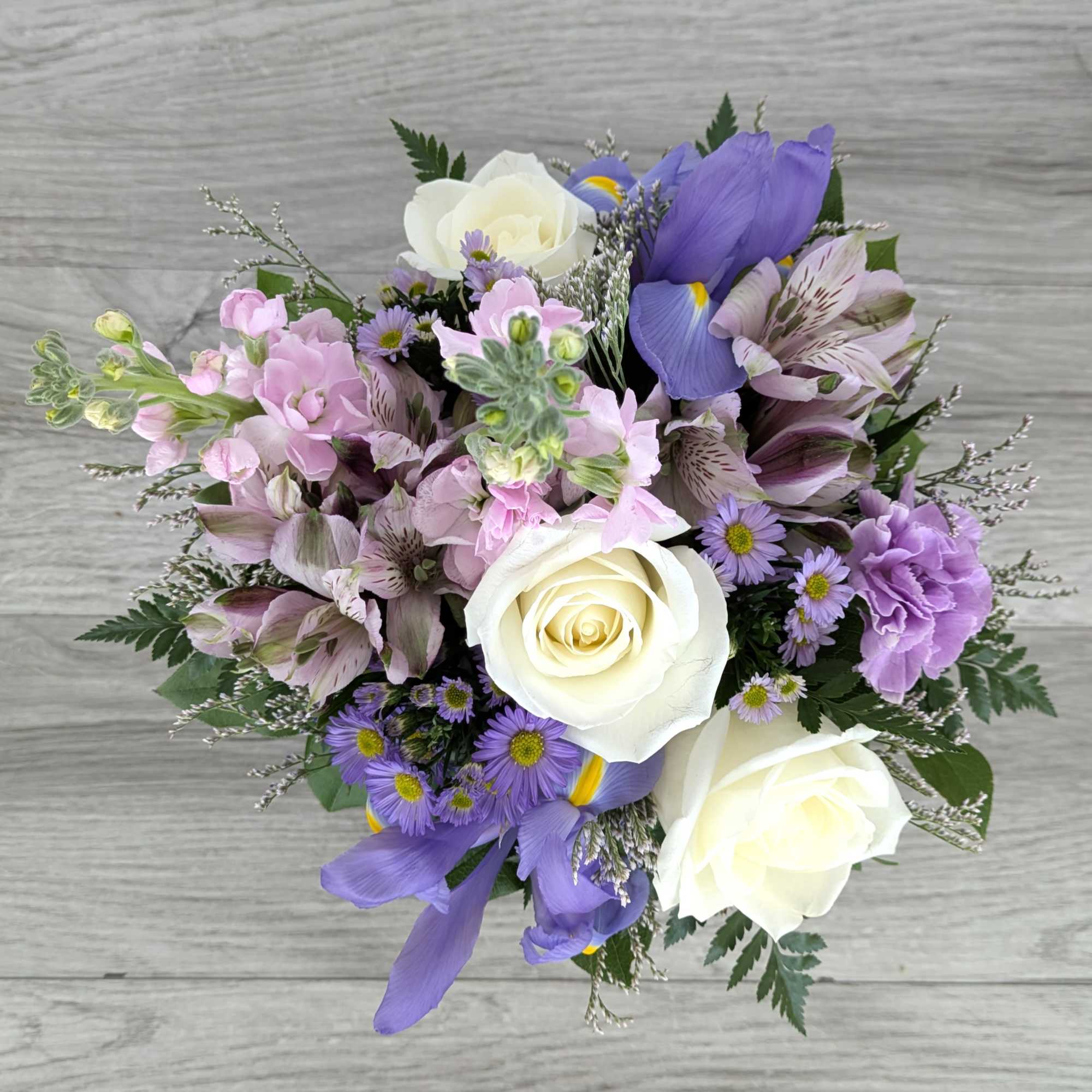 Bouquet of white roses, purple flowers, and pink blooms