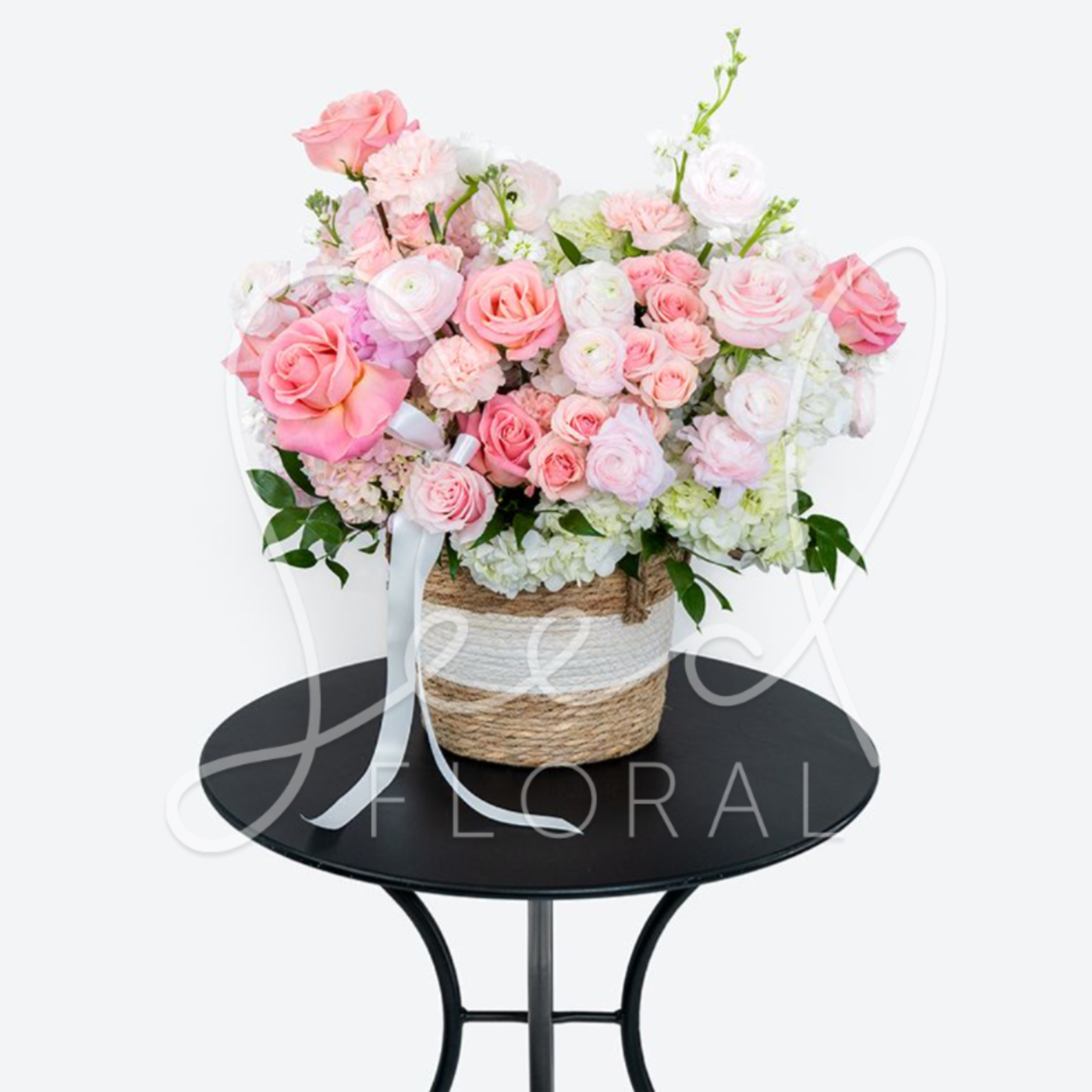 Pink and white rose arrangement in a woven basket