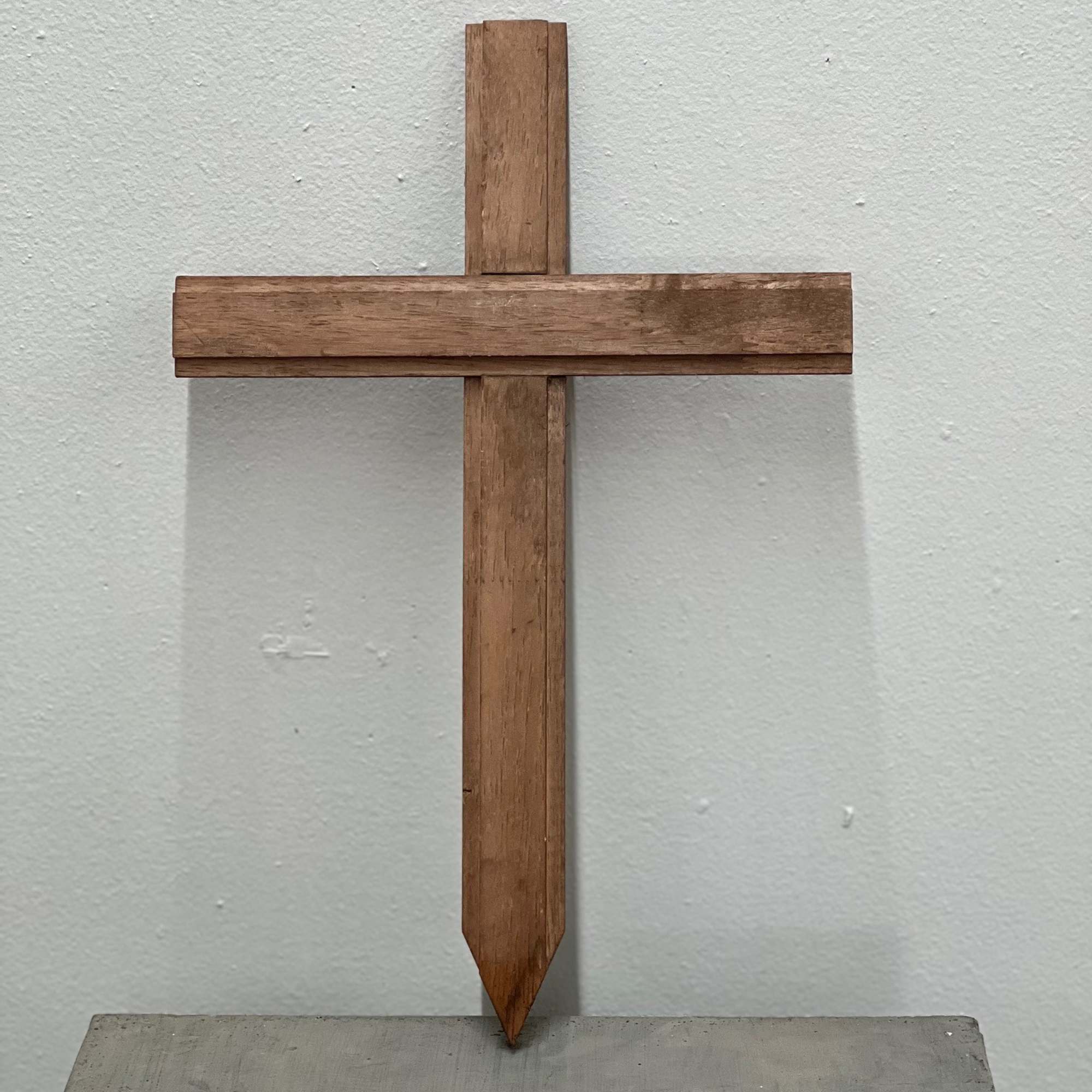 Wooden cross mounted against a plain wall