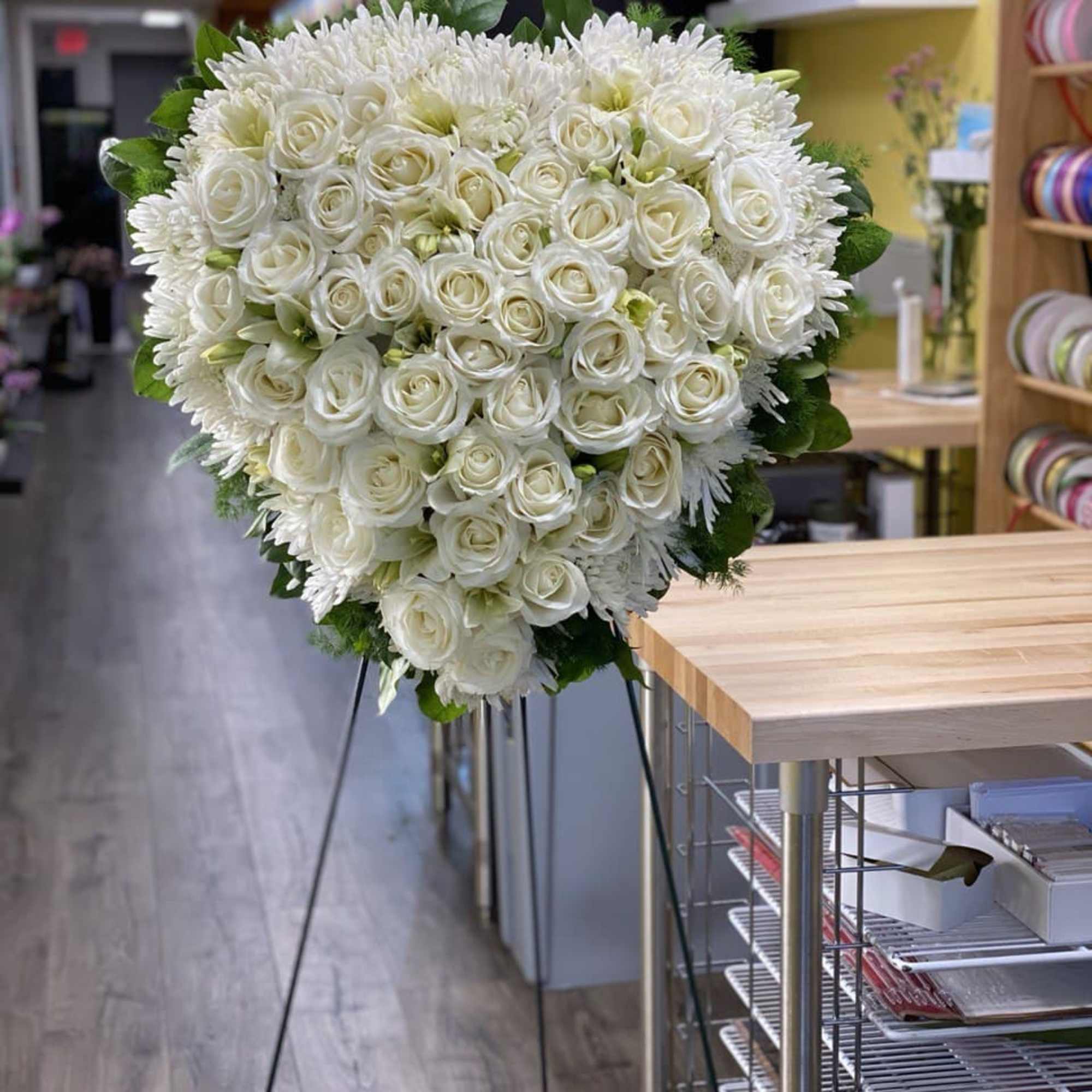 Large white rose and chrysanthemum standing spray on an easel