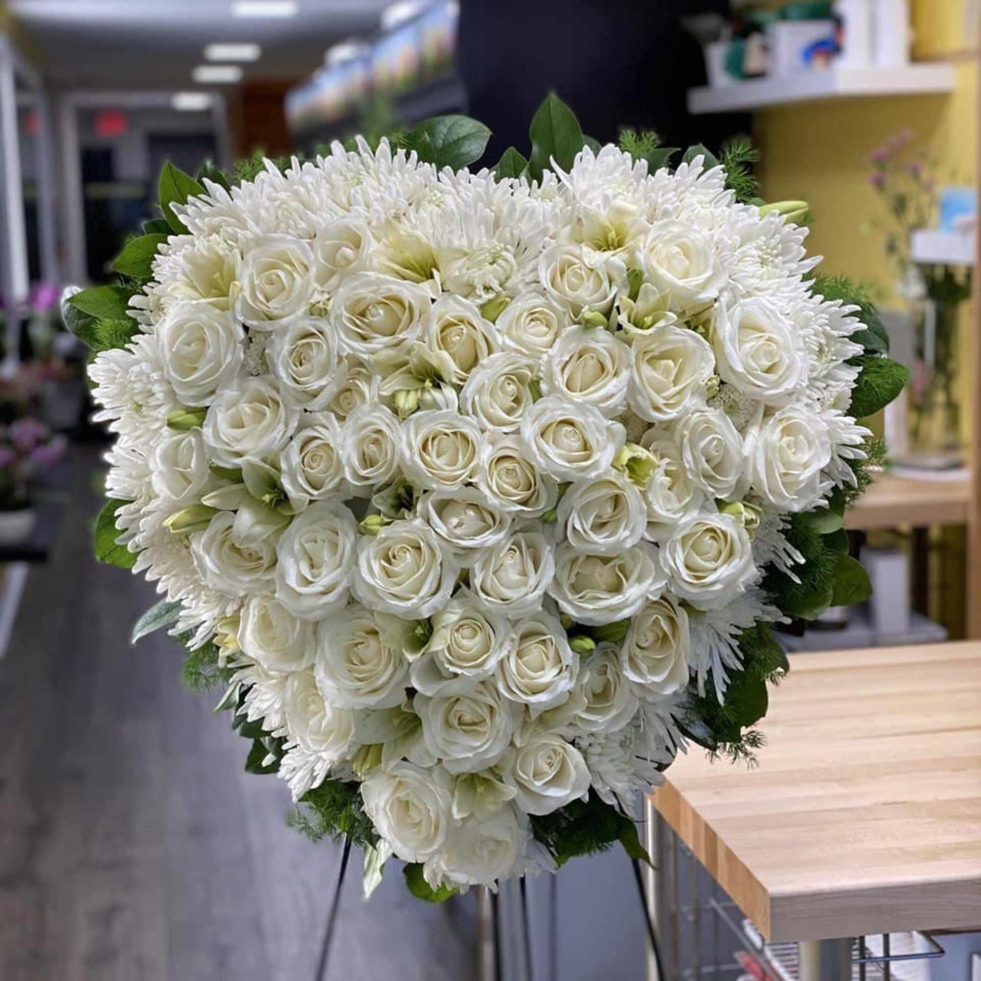 Heart-shaped bouquet of white roses and white chrysanthemums