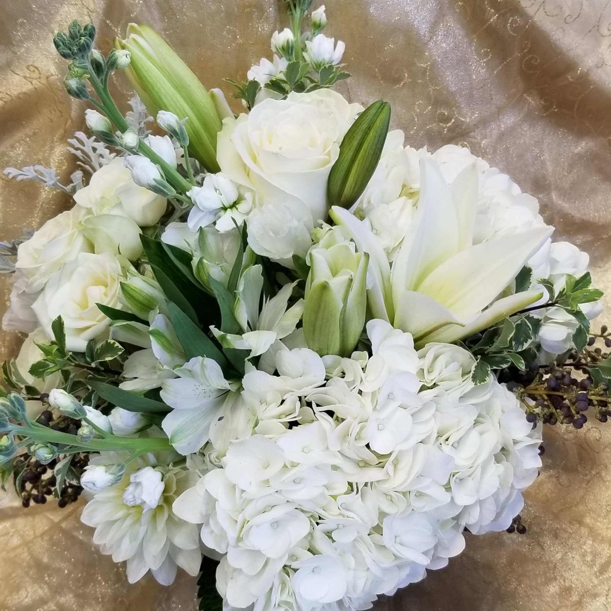White floral bouquet with roses, lilies, and hydrangeas
