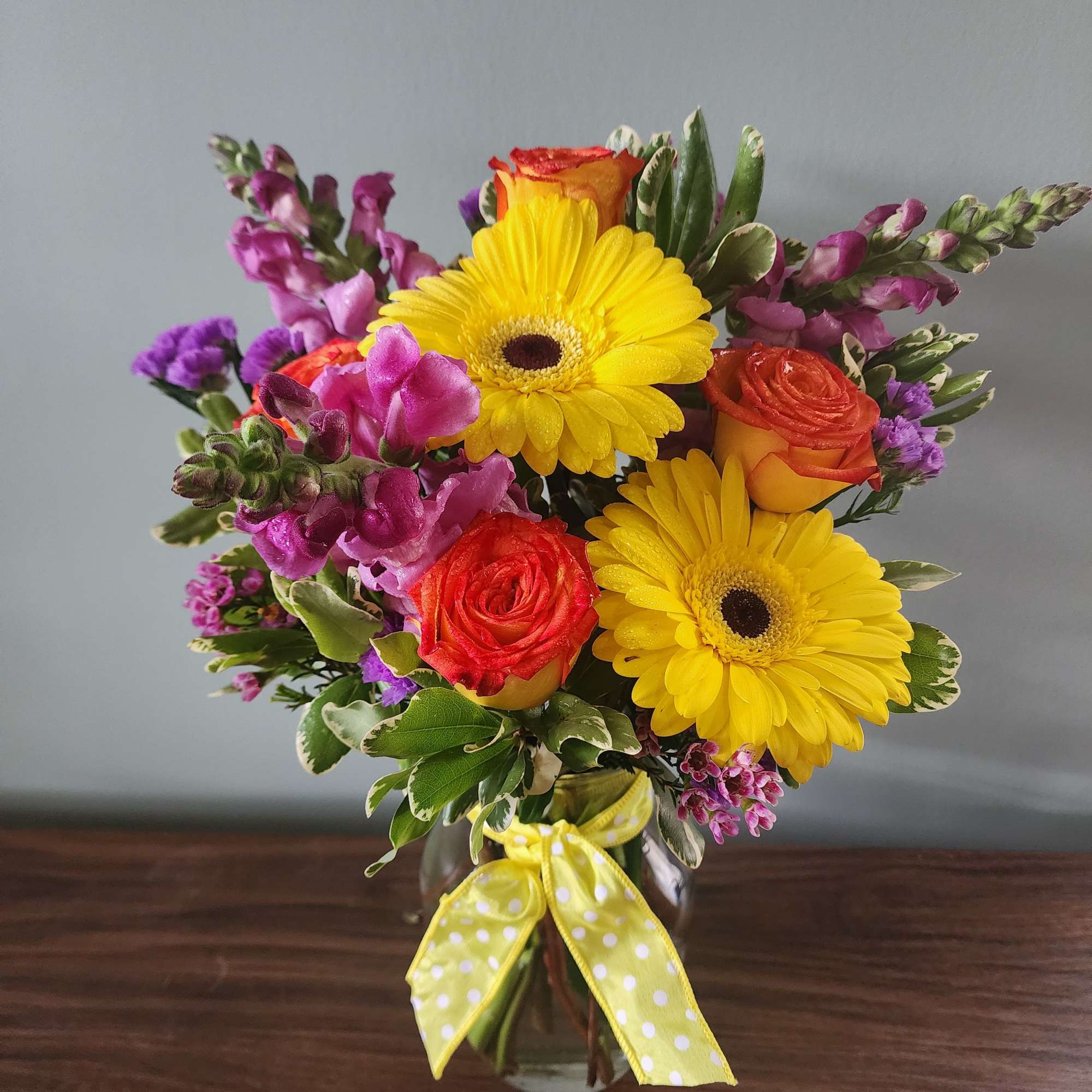 Bouquet of yellow gerbera daisies and orange roses in a glass vase, photo 2 of 2