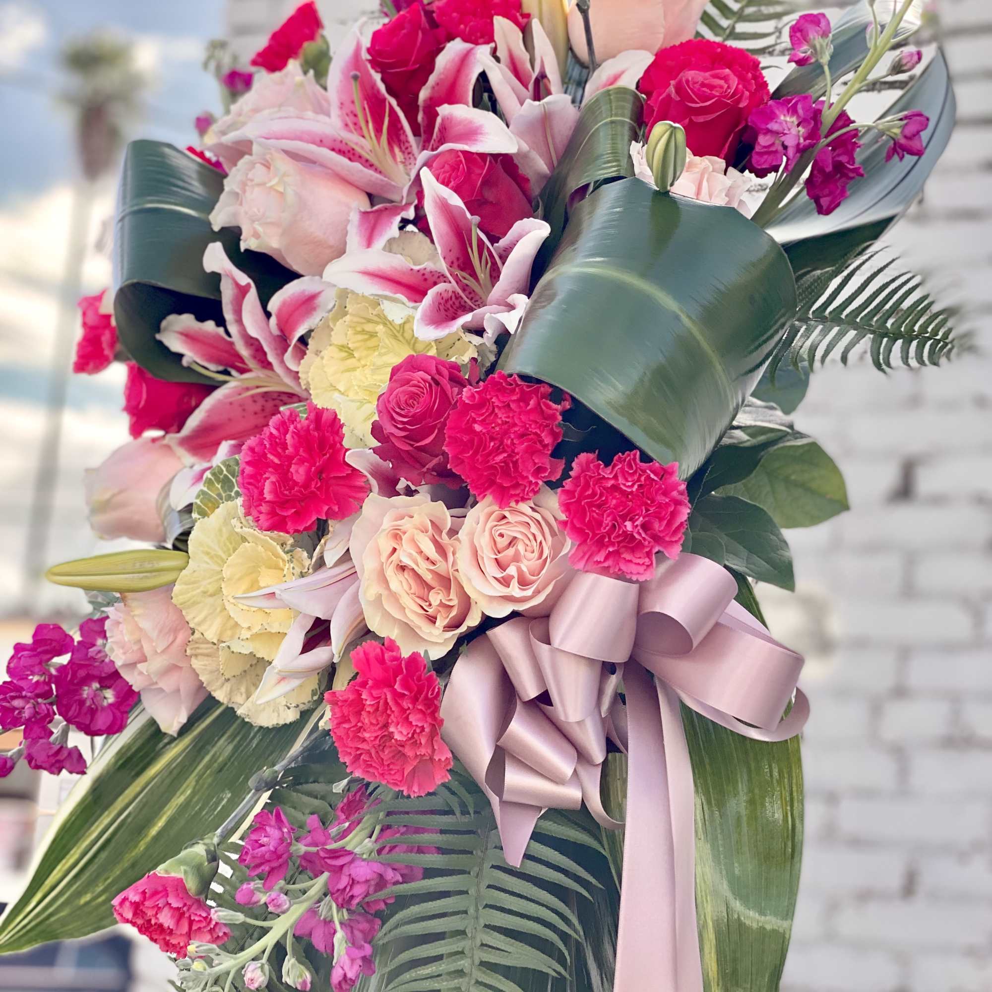 Pink and white floral standing arrangement with a ribbon bow