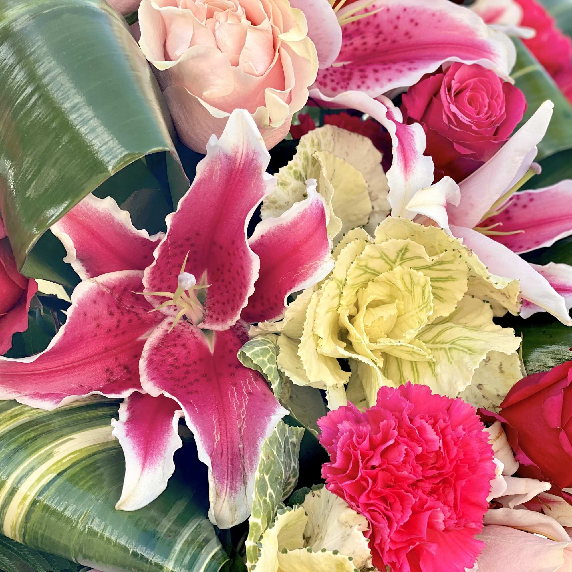 Pink lilies and roses with pale carnations in a close-up bouquet