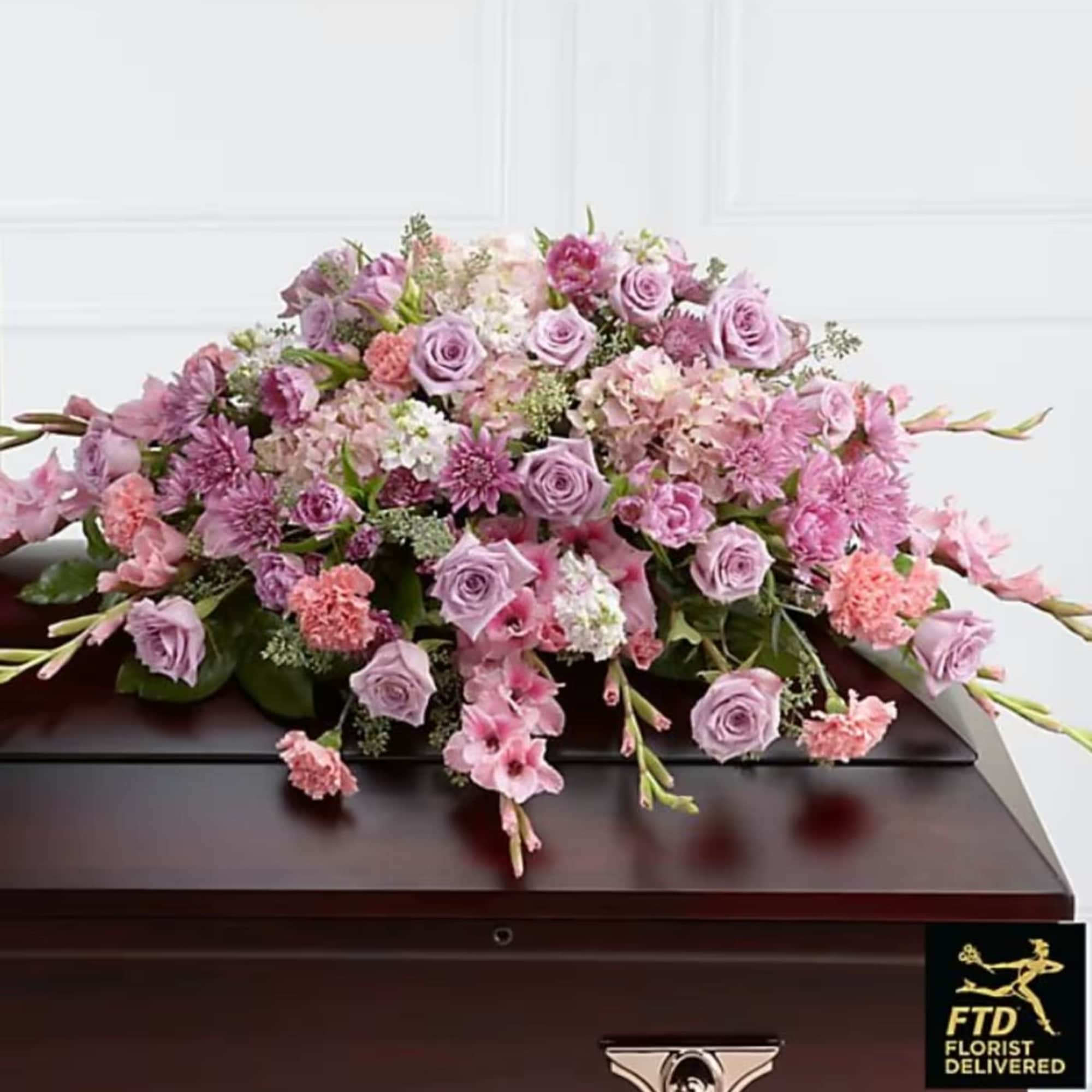 Pink and lavender floral casket spray with roses and carnations