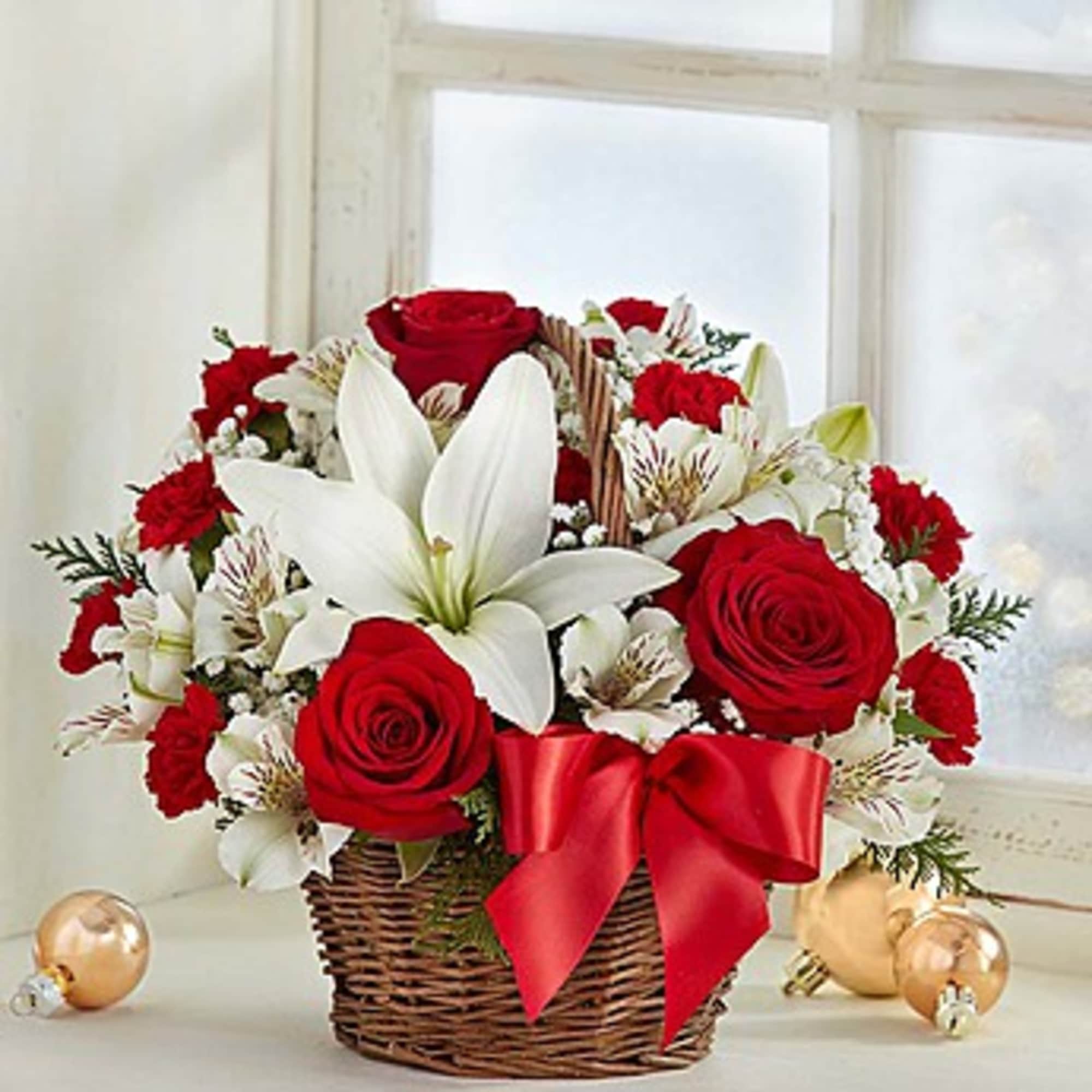 Basket arrangement of red roses and white lilies with a red bow