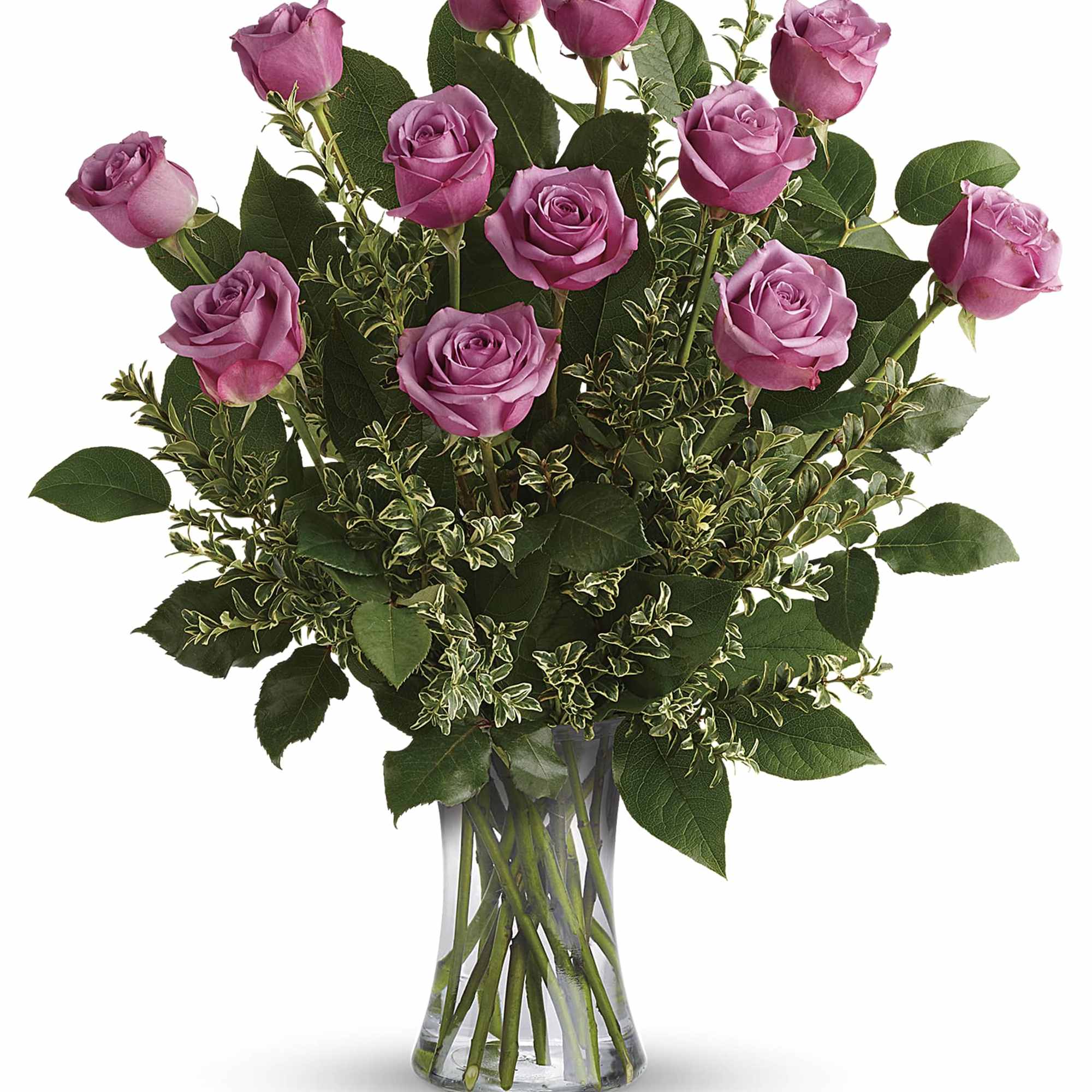 Pink roses arranged in a clear glass vase with mixed greenery
