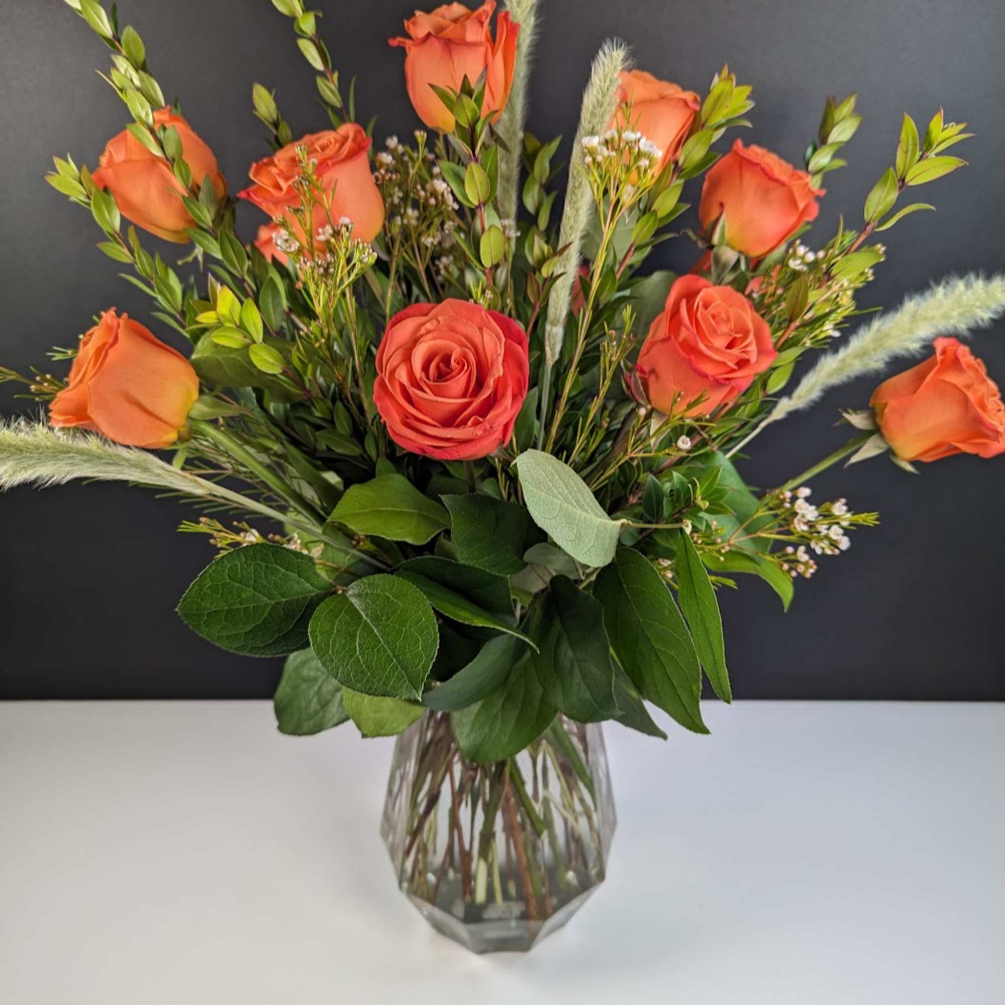Orange roses arranged in a clear glass vase
