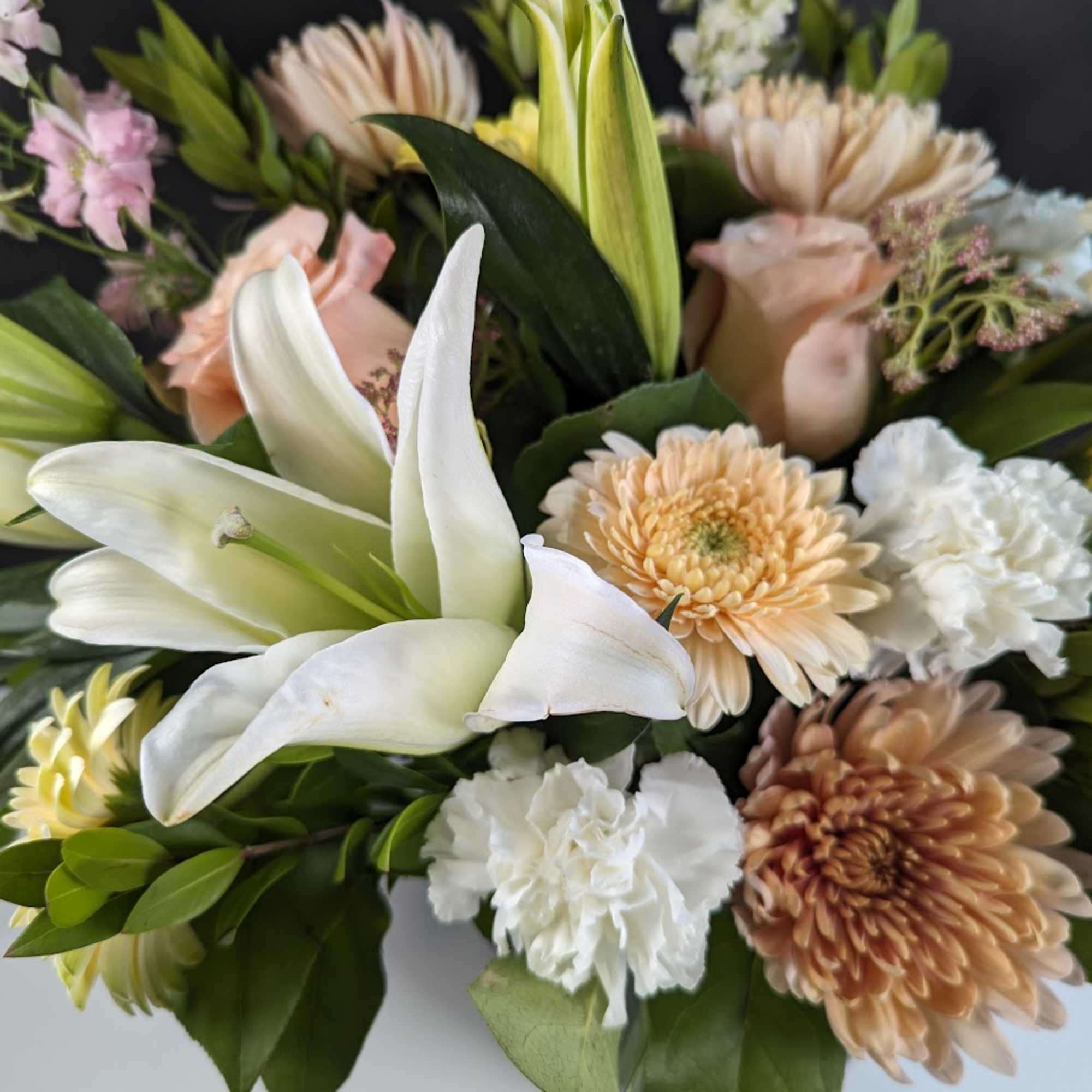 Bouquet of white lilies, peach chrysanthemums, and white carnations