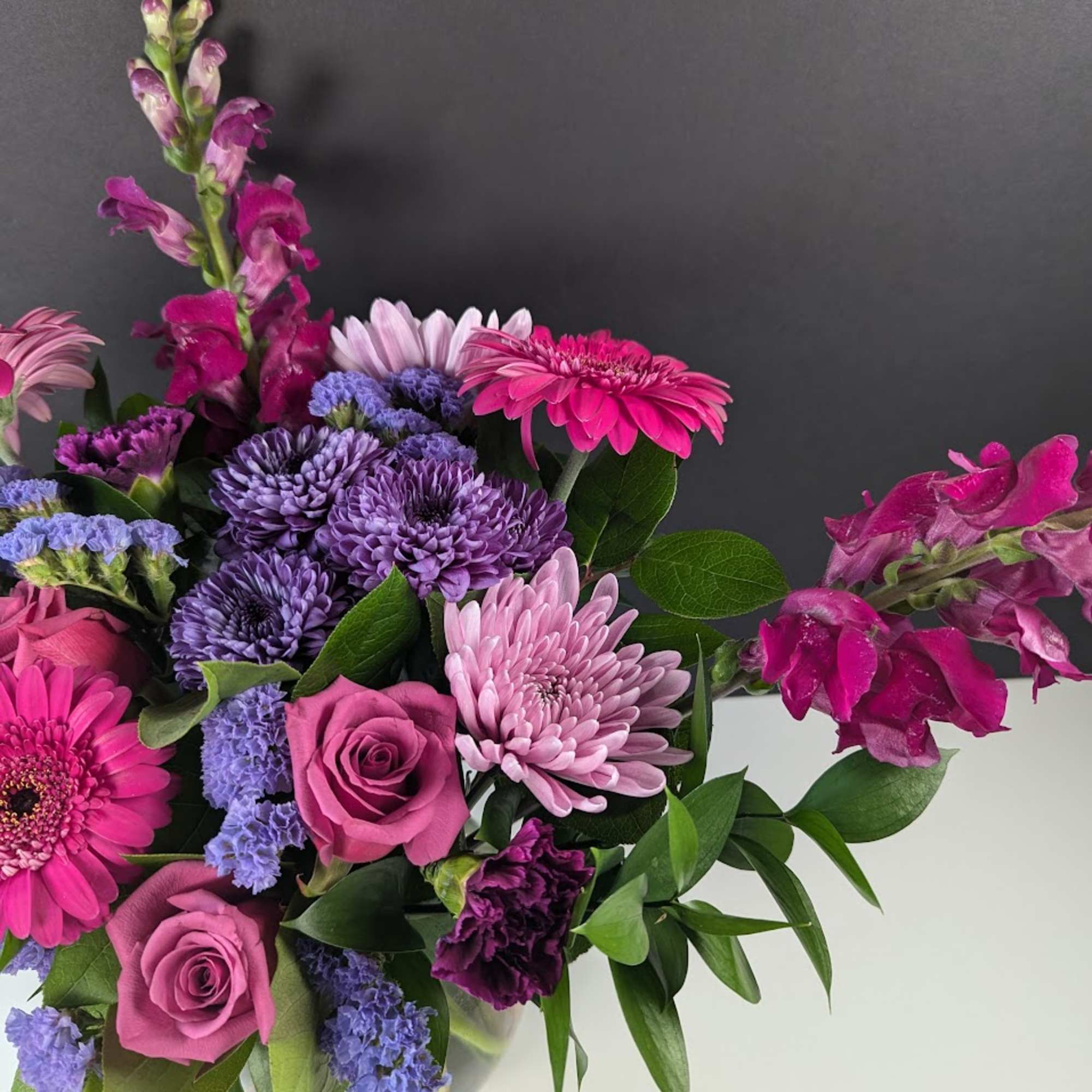 Pink and purple mixed bouquet with roses, chrysanthemums, and snapdragons