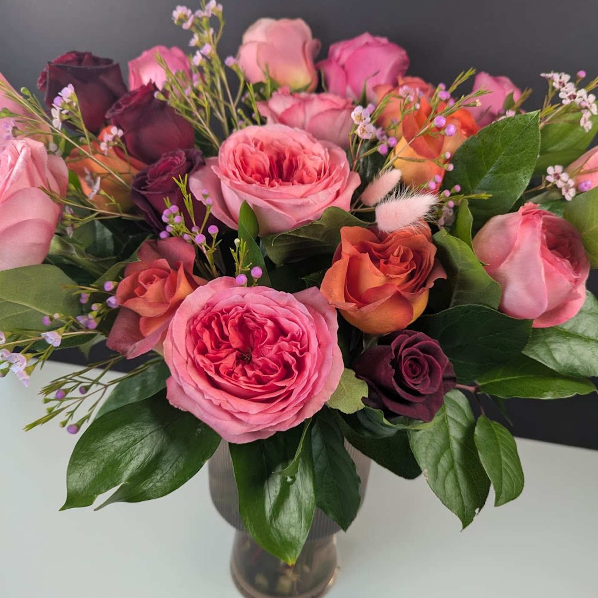 Pink and purple roses arranged in a glass vase
