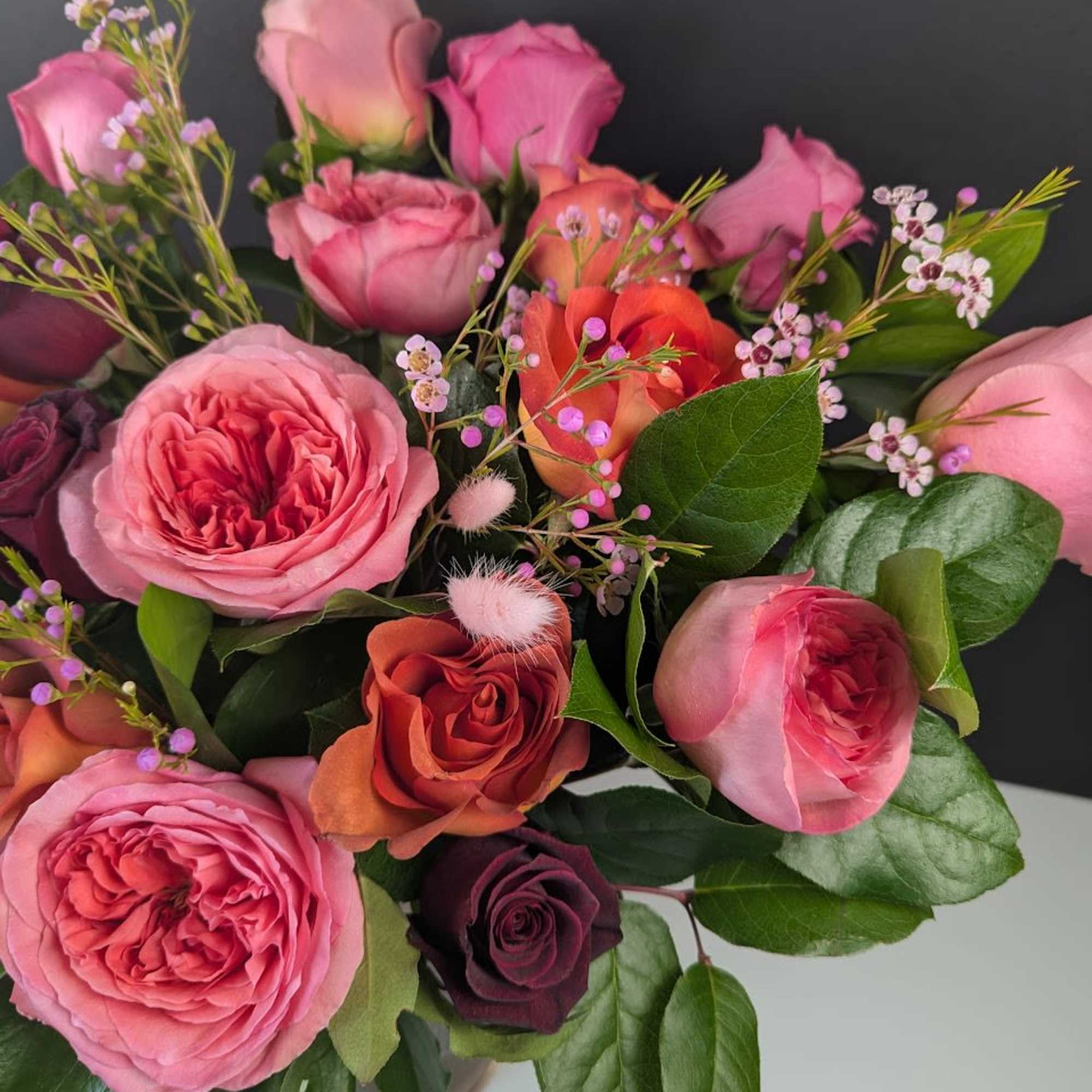 Bouquet of pink and orange roses with small filler flowers