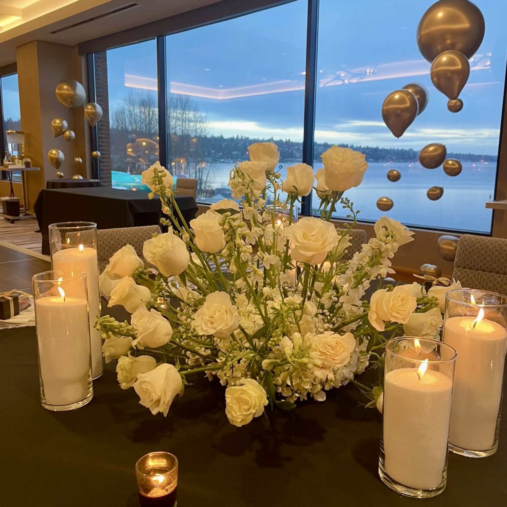 White rose centerpiece with candles on a table