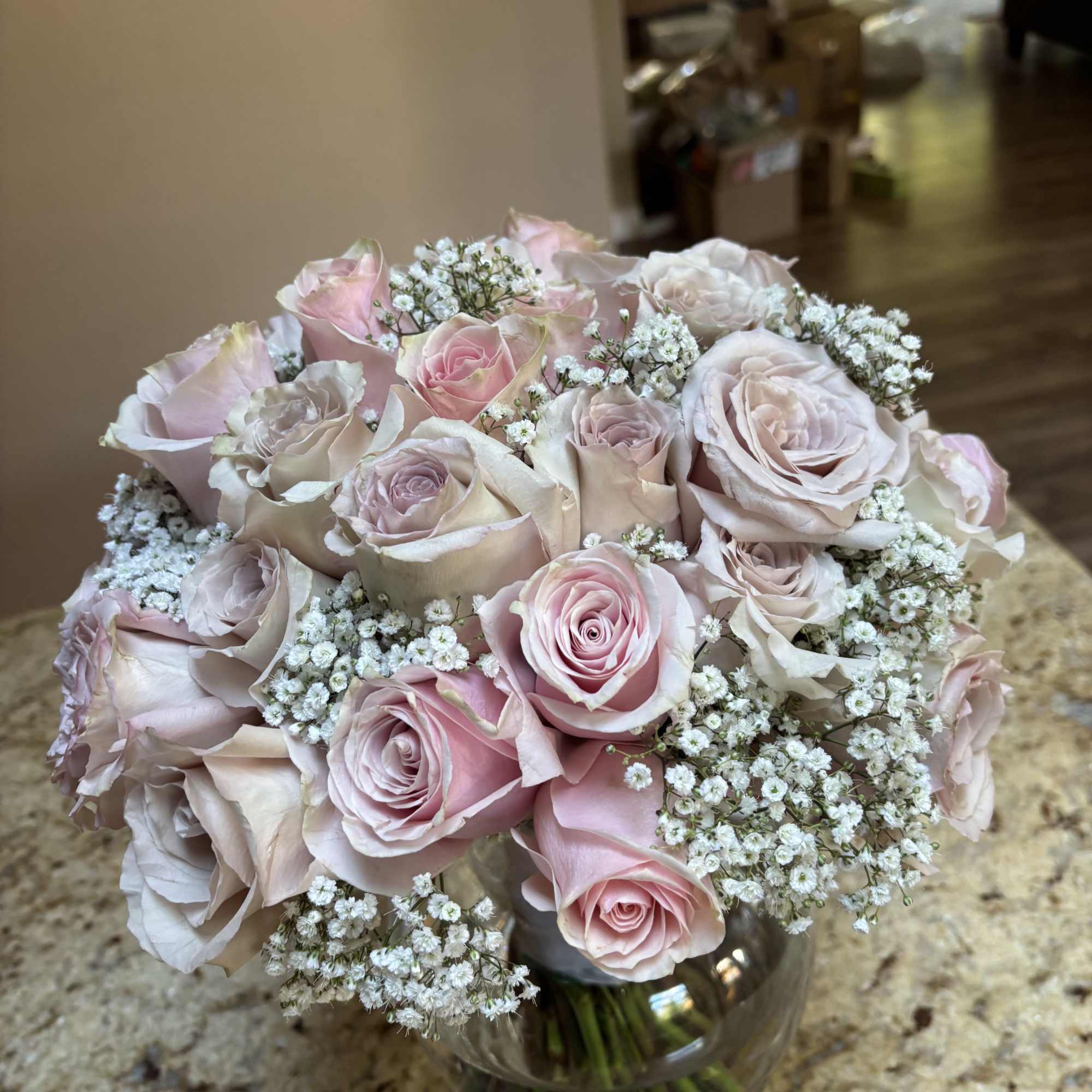 Bouquet of pale pink roses and baby's breath in a glass vase