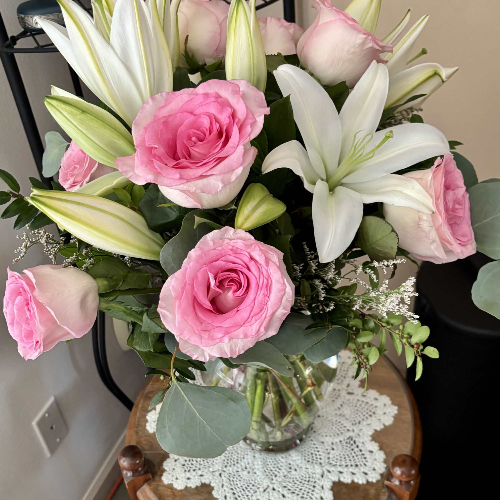 Pink roses and white lilies arranged in a clear glass vase