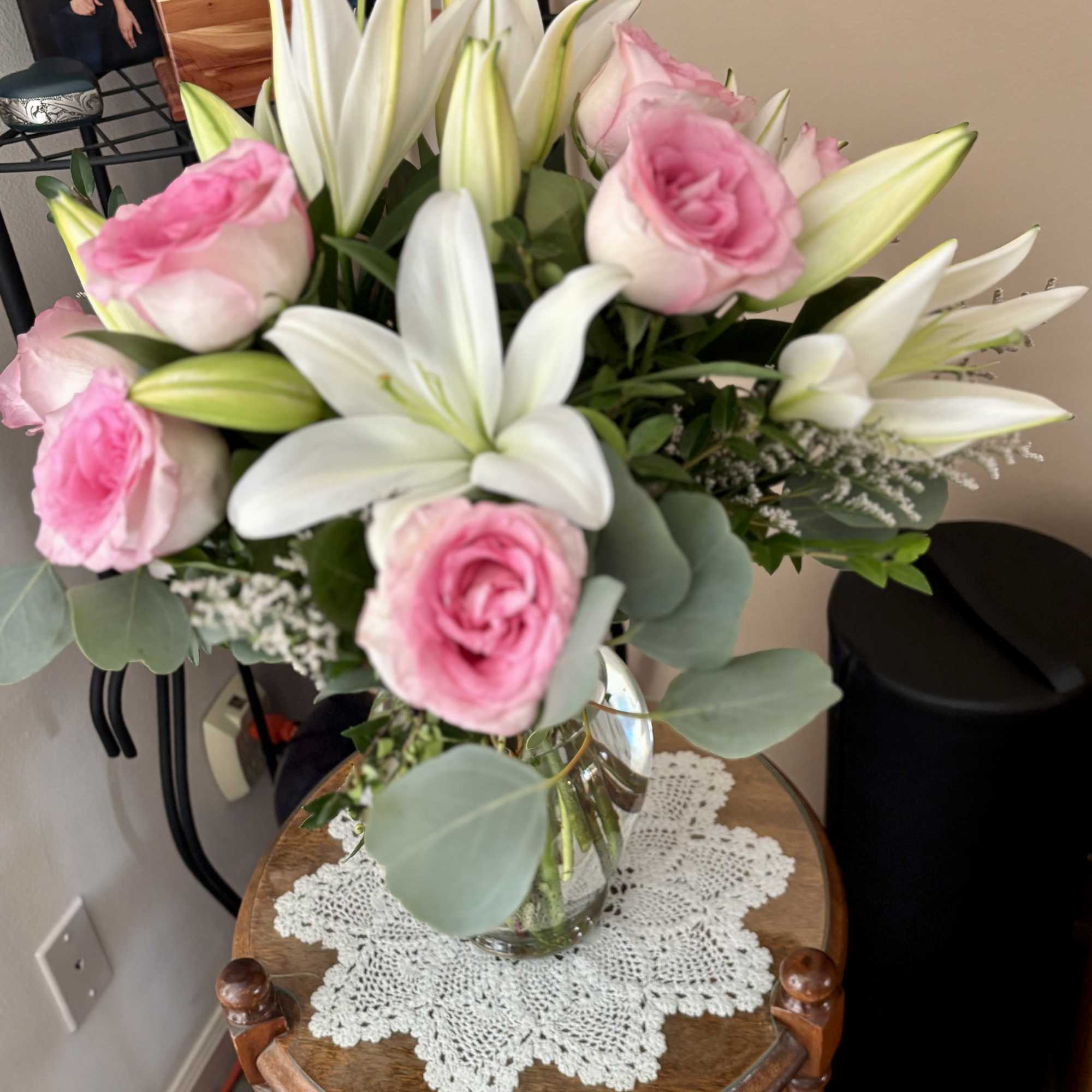 Pink roses and white lilies in a clear glass vase