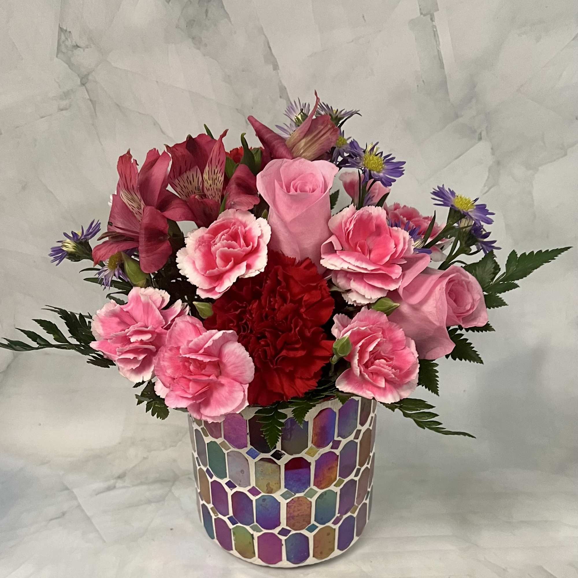Pink and red mixed bouquet in a colorful mosaic vase
