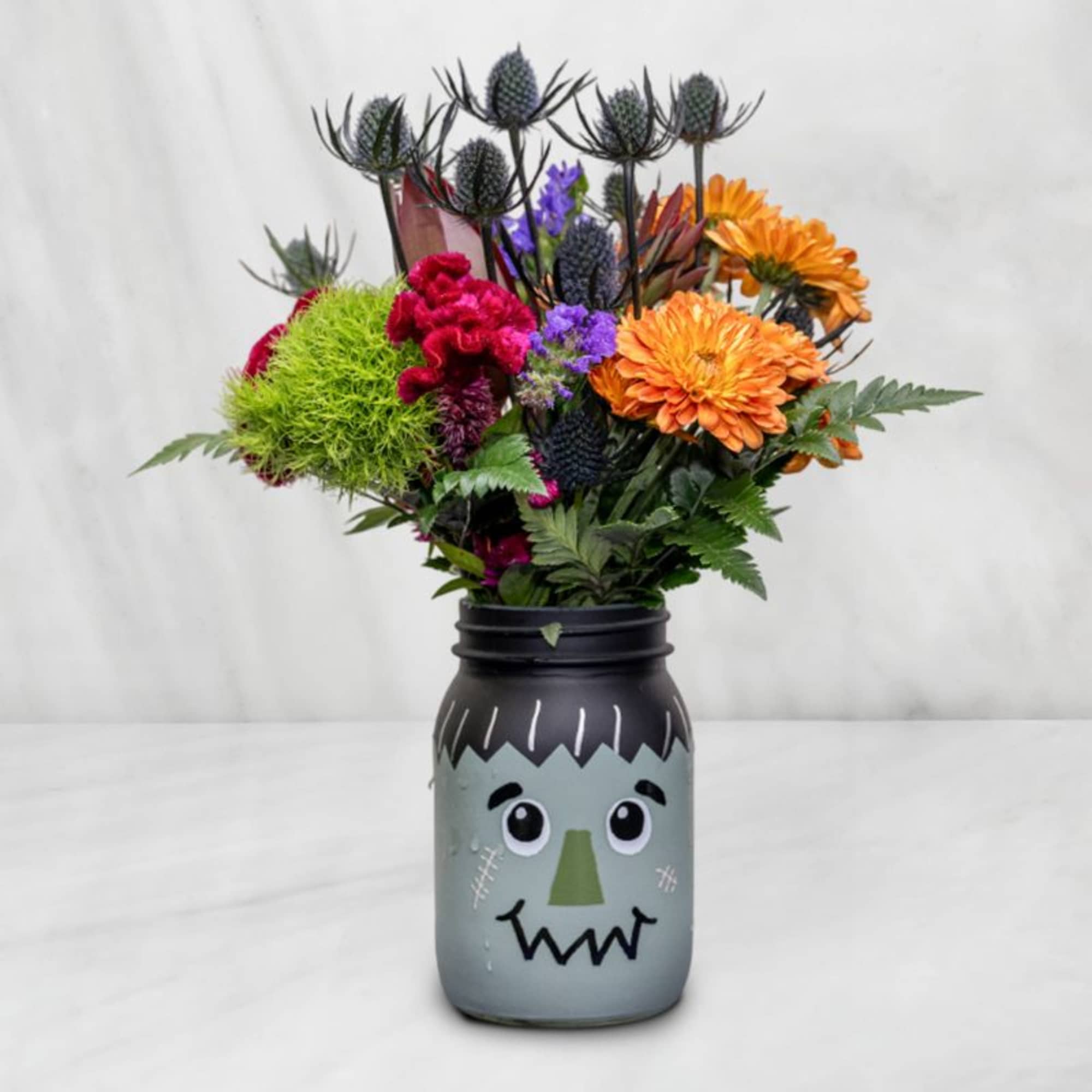 Colorful bouquet in a Frankenstein face jar
