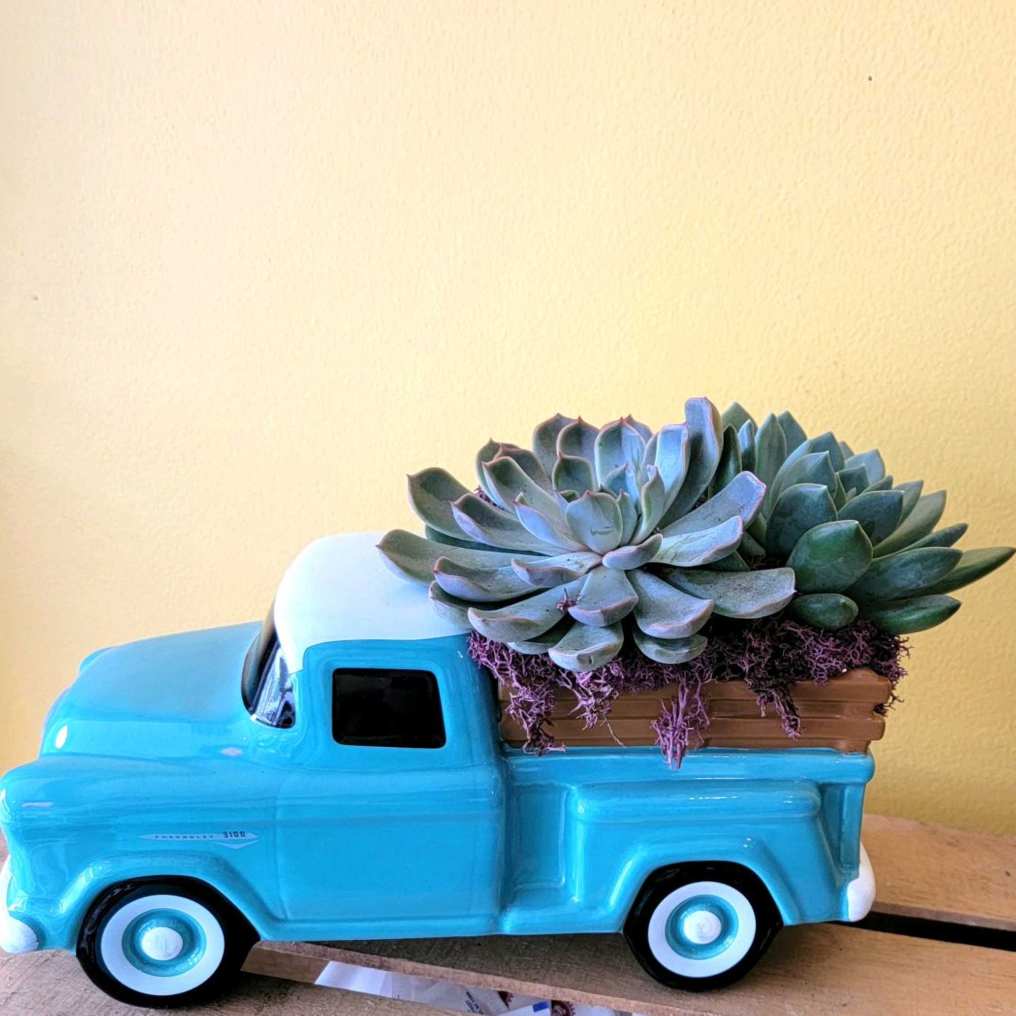 Blue ceramic truck planter with succulents in the bed