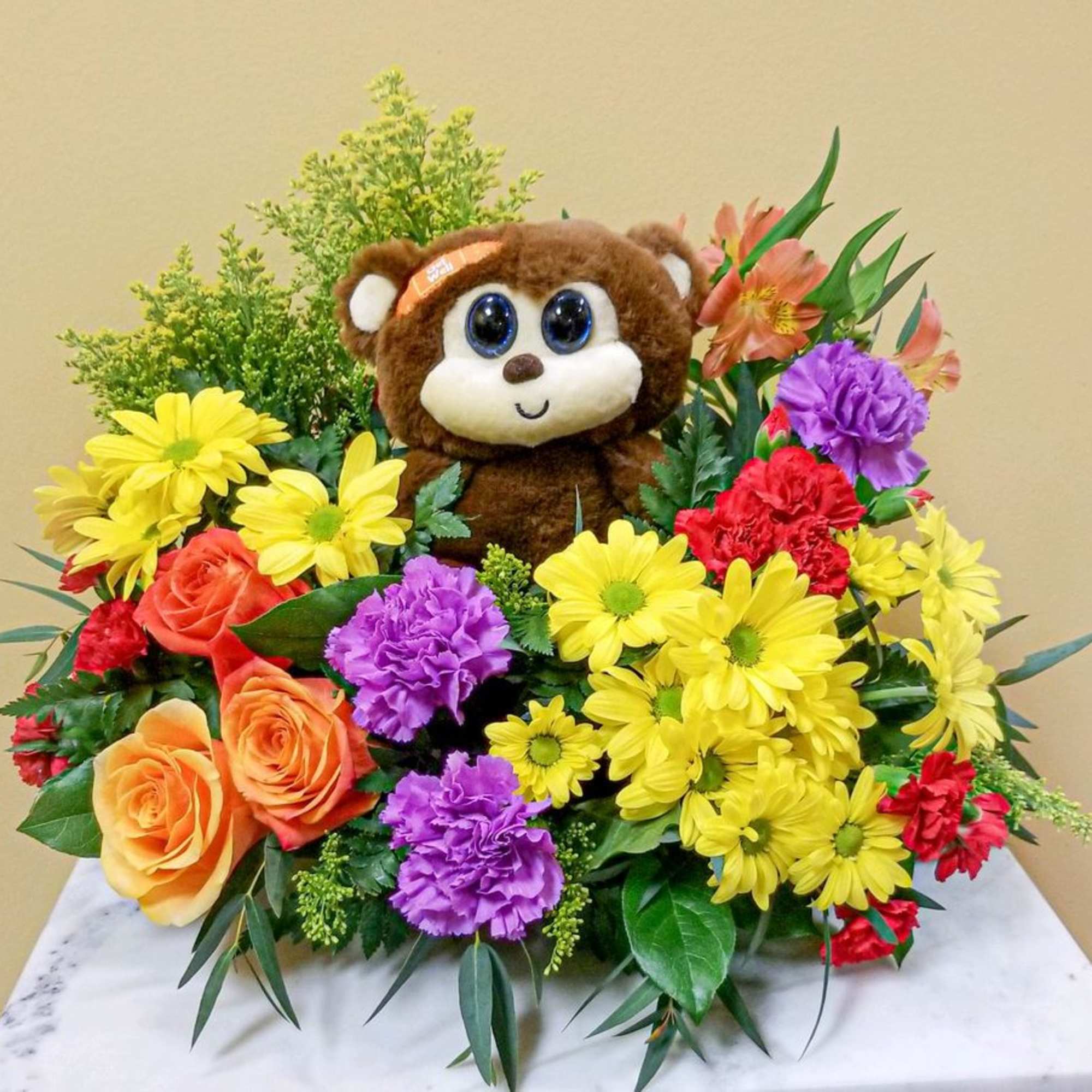 Bouquet with a teddy bear surrounded by colorful flowers