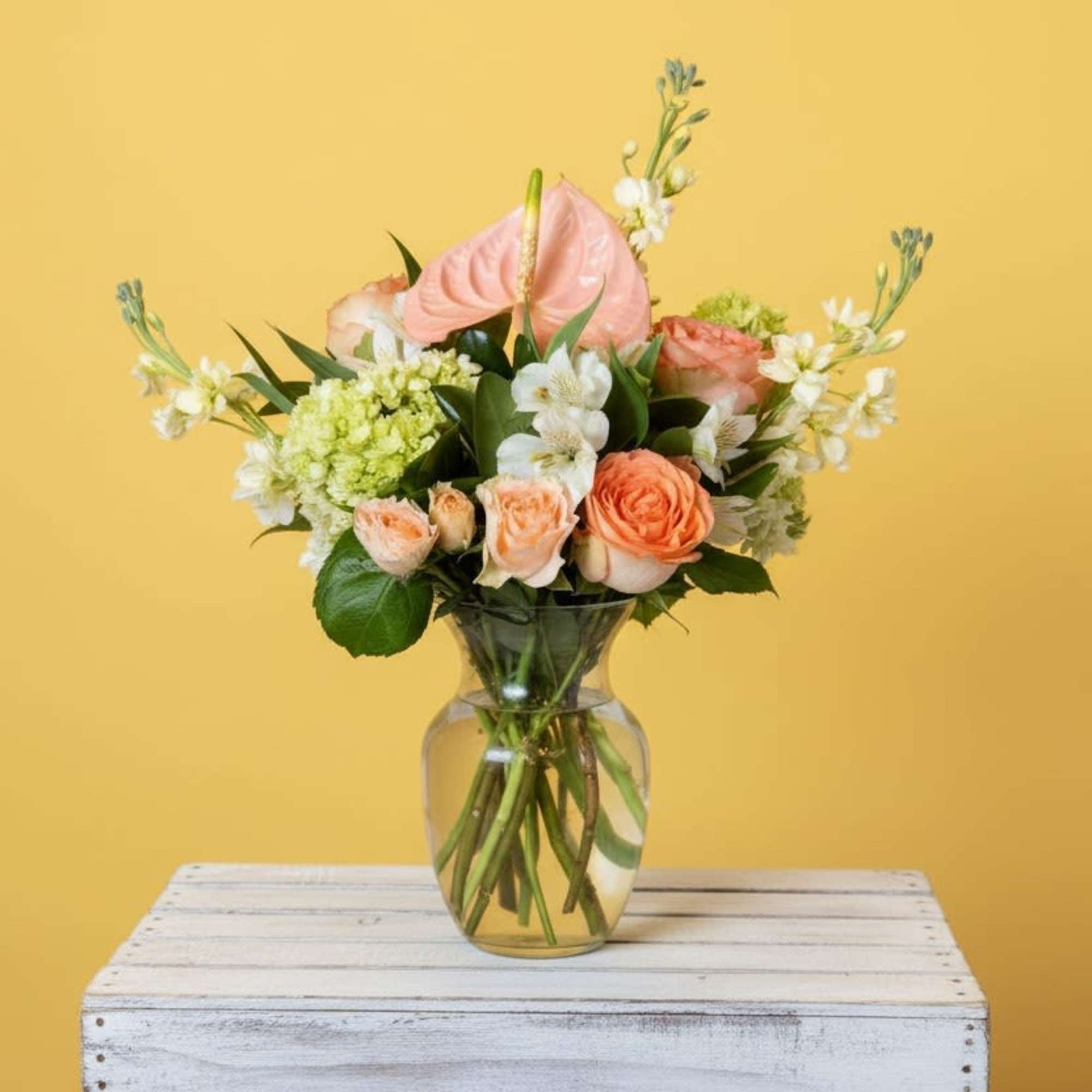 Soft peach roses and blooms give this flower arrangement a warm, uplifting