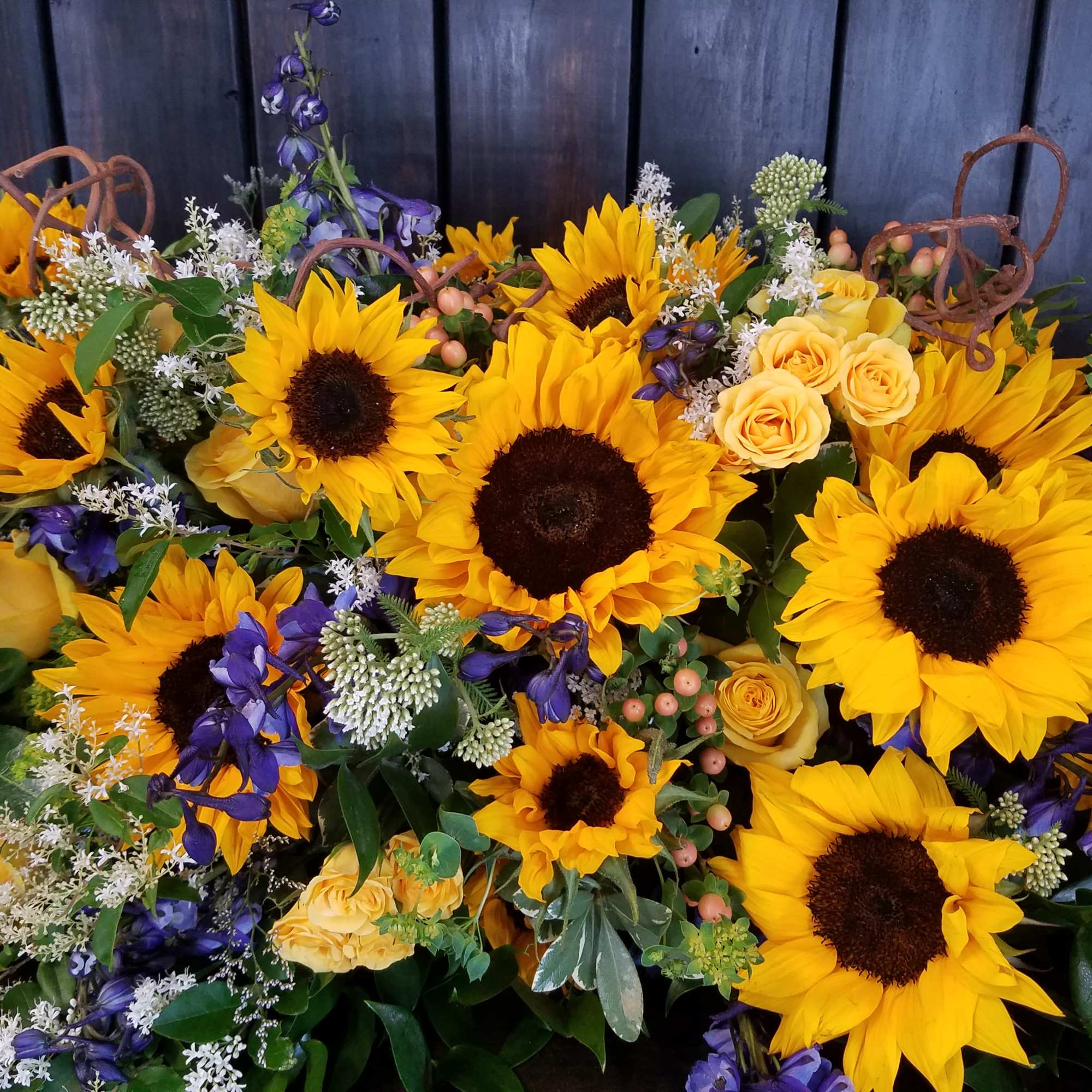 Bouquet of sunflowers, yellow roses, and purple flowers